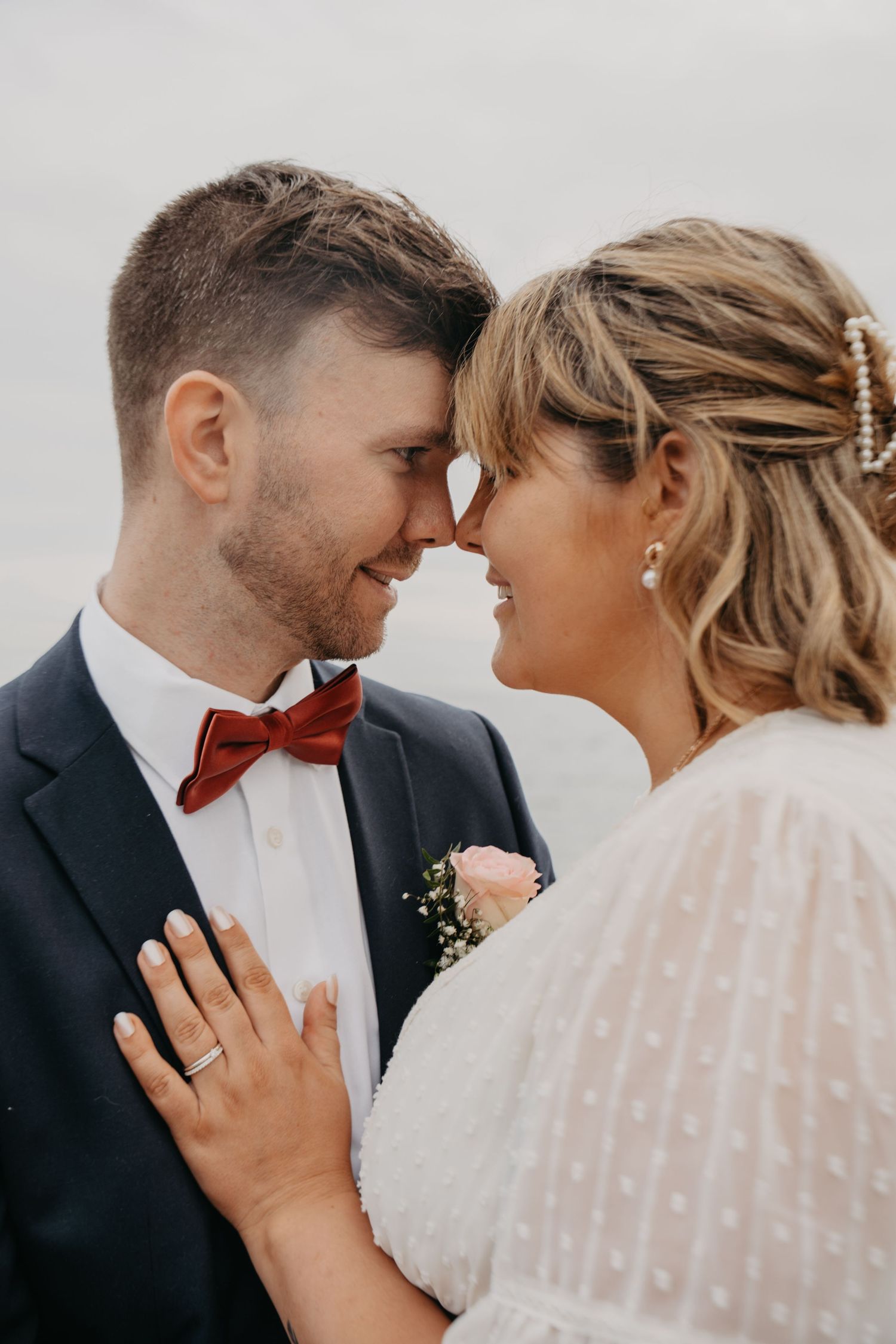 Close-up wedding portrait showing tender moment between newlyweds in soft lighting.
