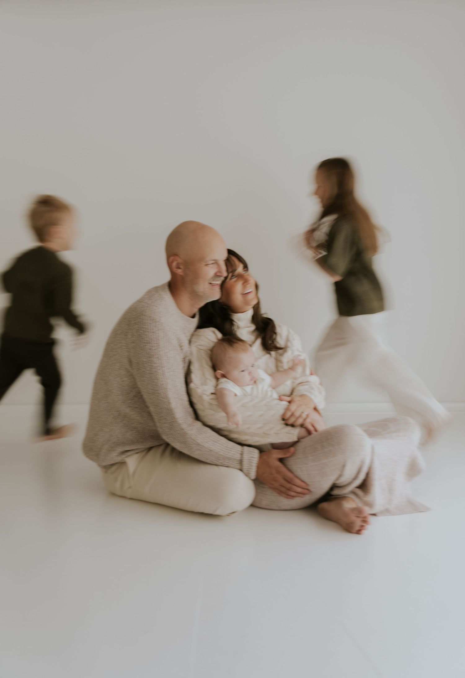 Motion blur family portrait series showing intimate moments against white background.