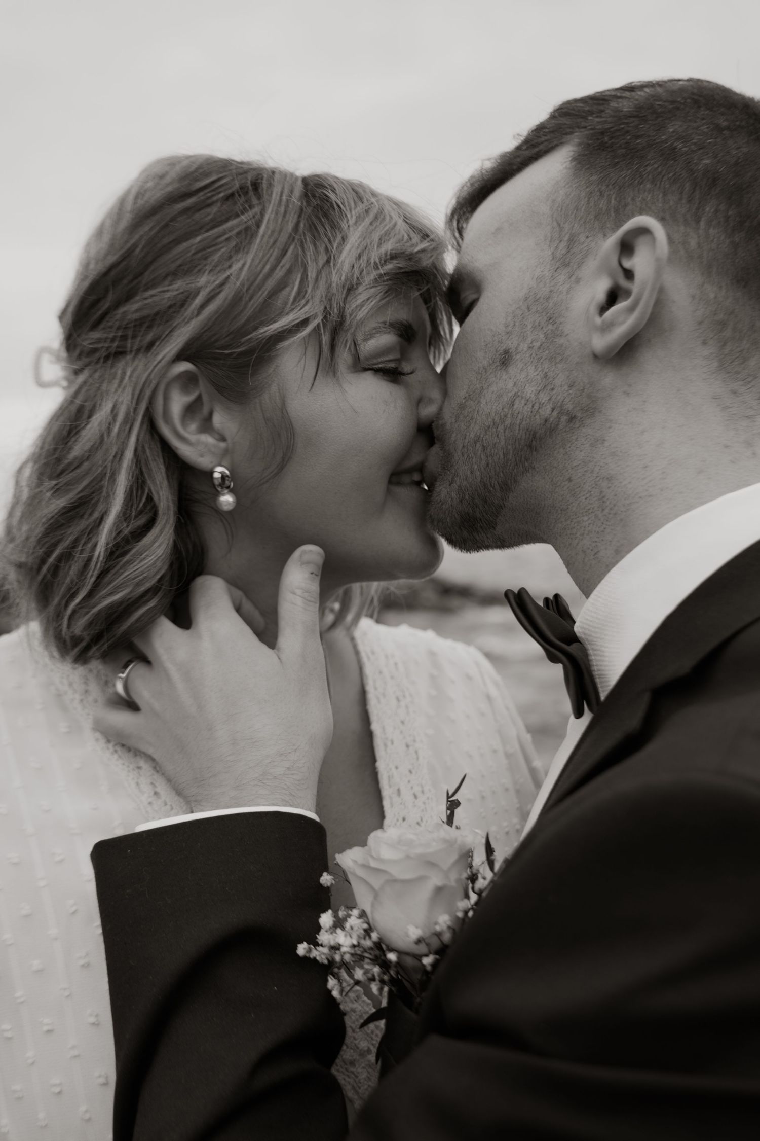 Intimate black and white close-up of wedding couple's romantic moment.