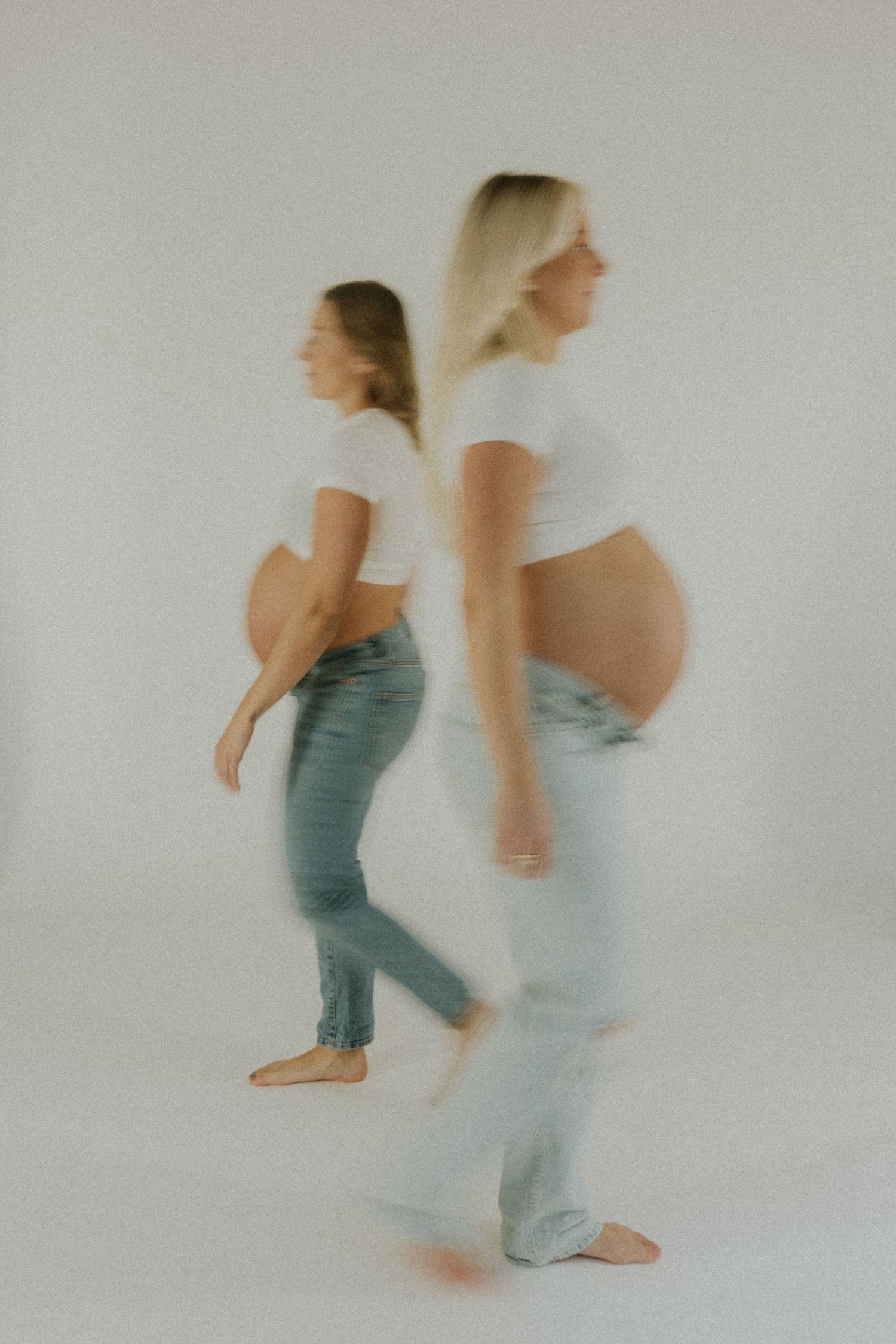 Motion blur series of two people walking and interacting against a light studio background.