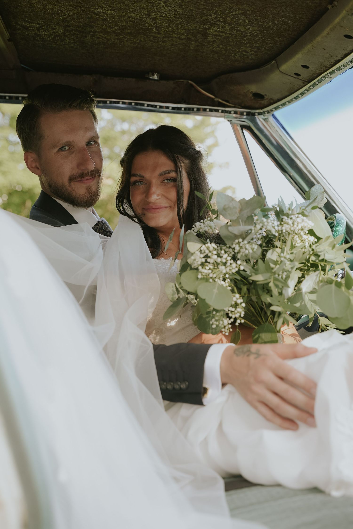 A series of candid moments inside a wedding car with a white dress and delicate white floral bouquet.