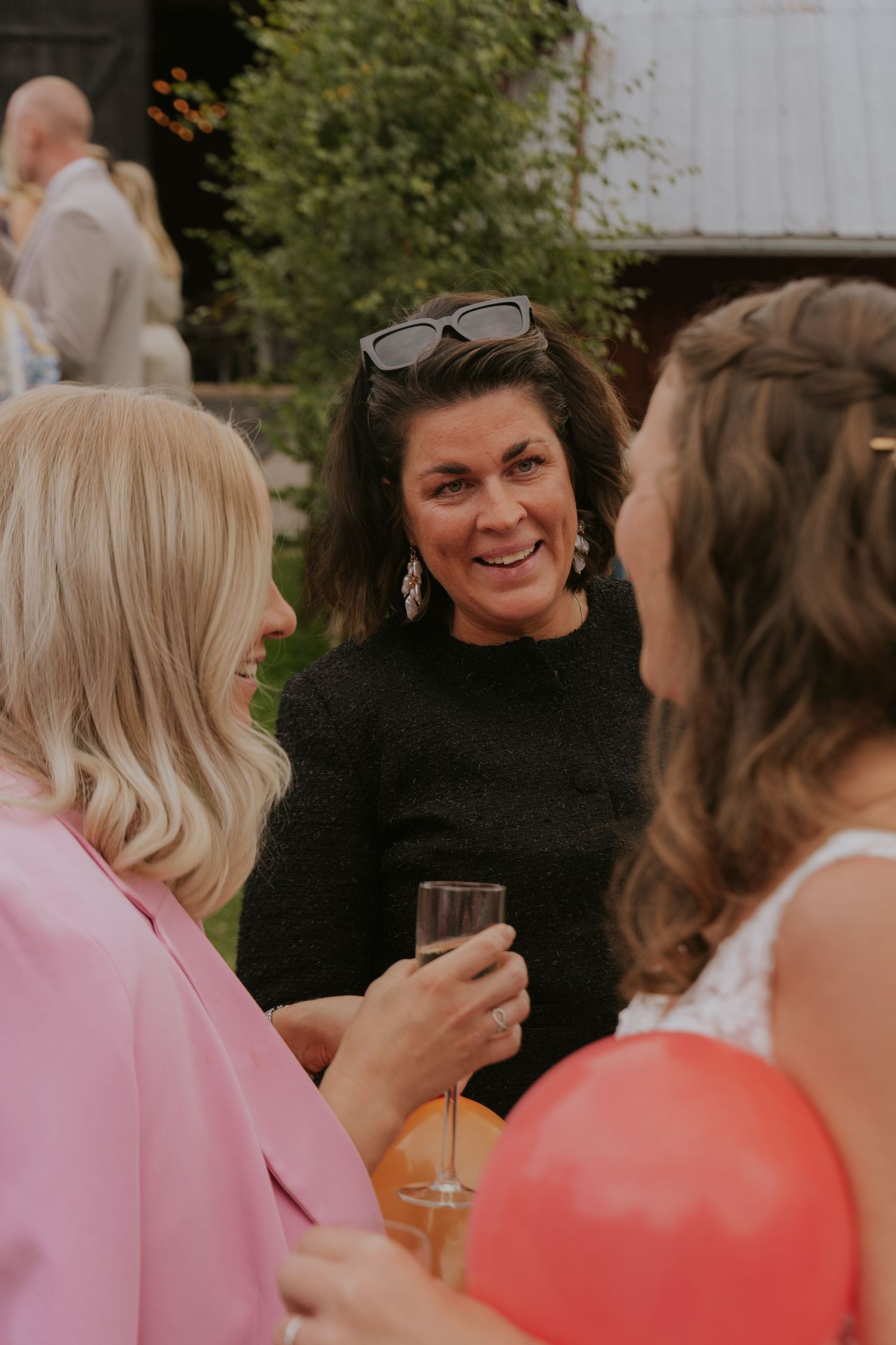 Guests at an outdoor wedding reception sharing joyful moments and laughter.
