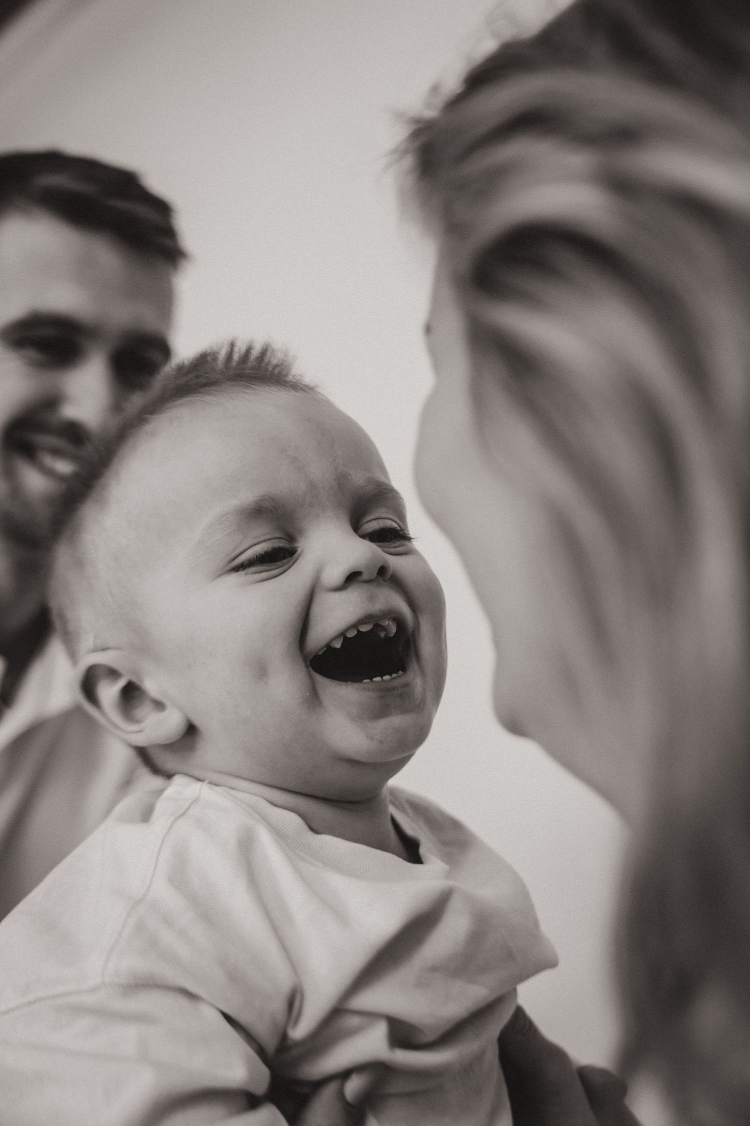 Black and white series of candid moments showing pure joy and laughter between a parent and child.