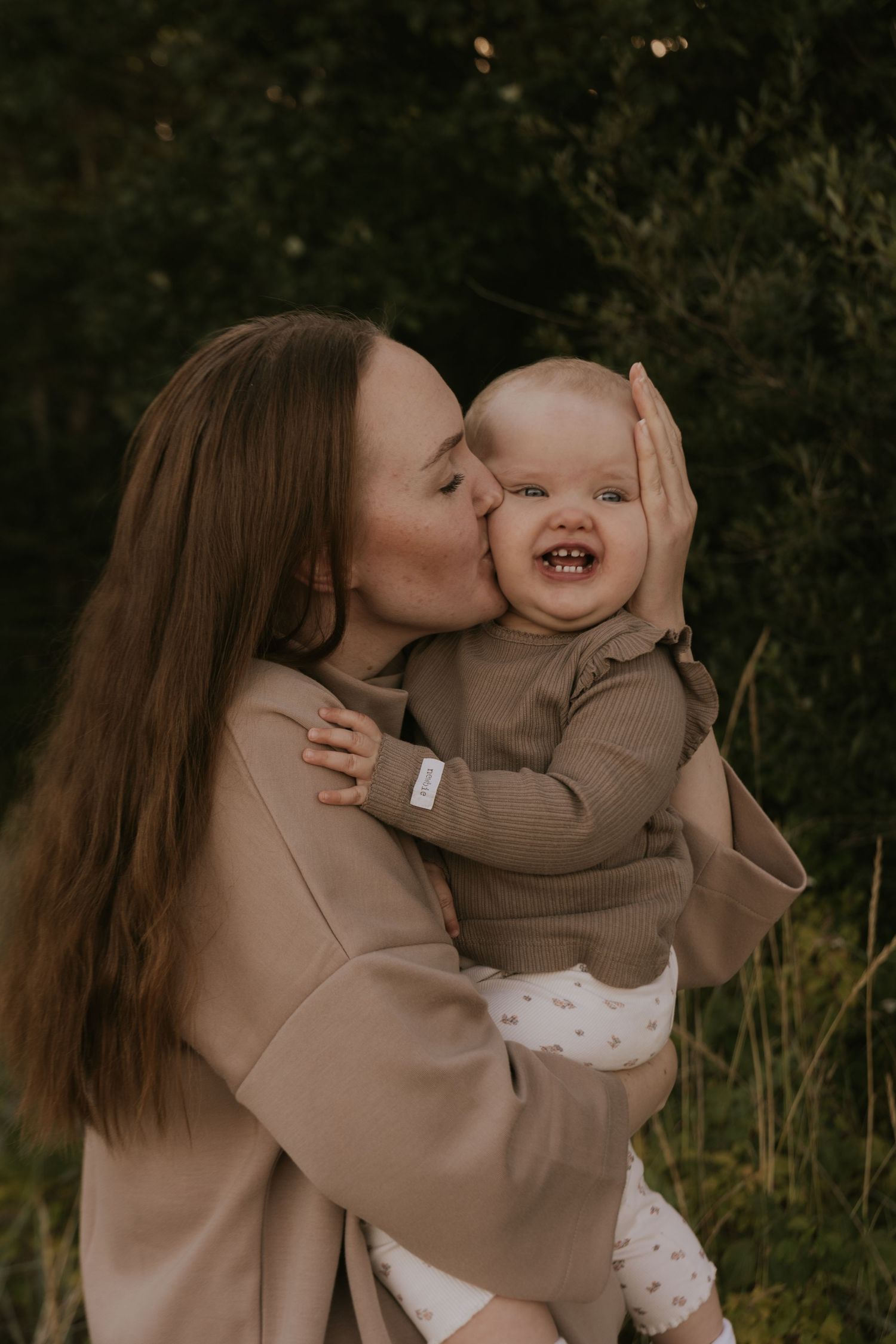 Sweet candid moments captured between two people in matching beige outfits outdoors.