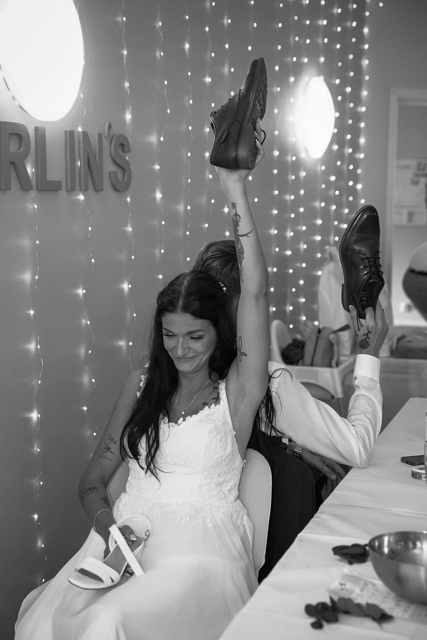 Wedding celebration with twinkling lights and joyful dancing in white dresses.