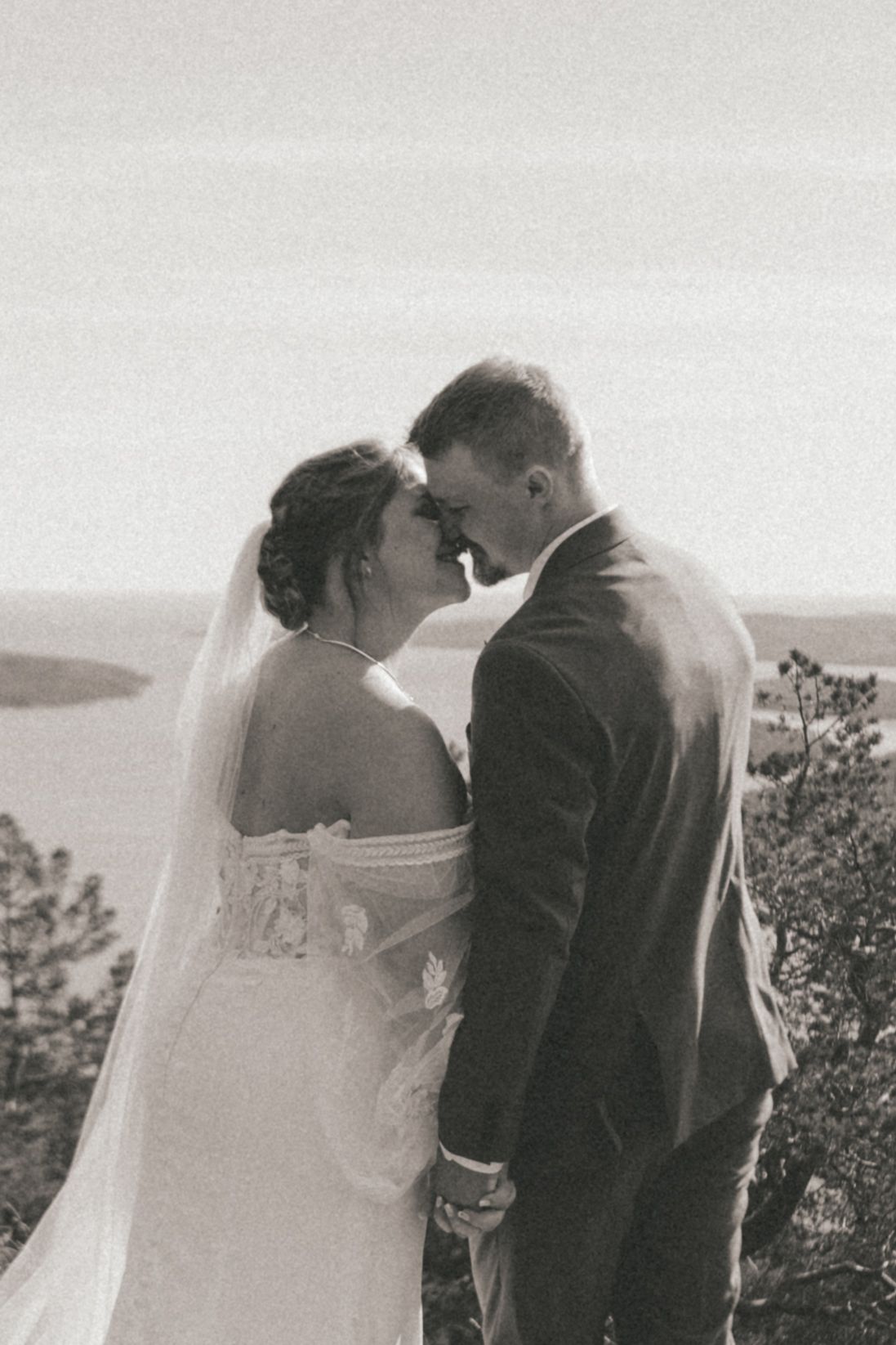 Intimate black and white wedding portraits capturing loving moments between bride and groom outdoors.