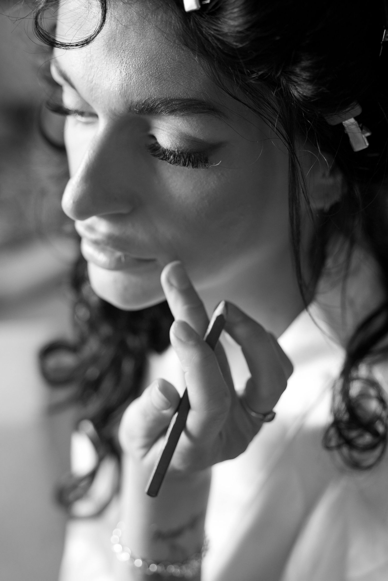 A black and white photo sequence shows someone applying lipstick in an artistic style.
