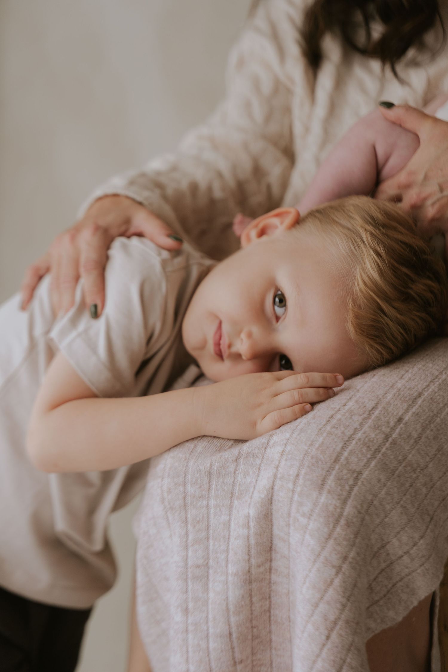 Artistic child portrait series showing gentle poses against neutral background.