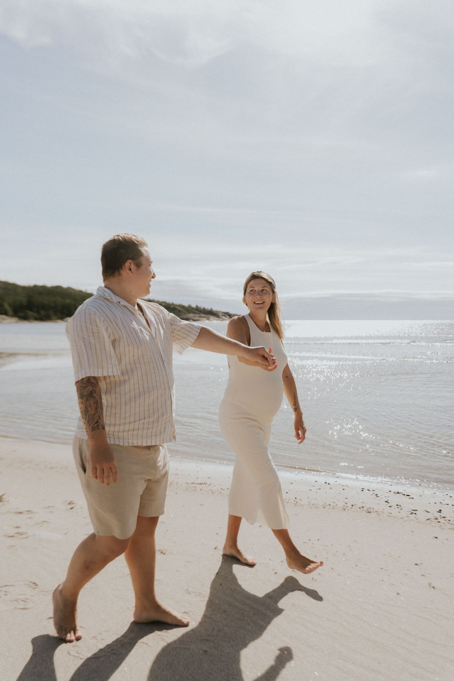 Joyful couple dancing and playing on a sandy beach.