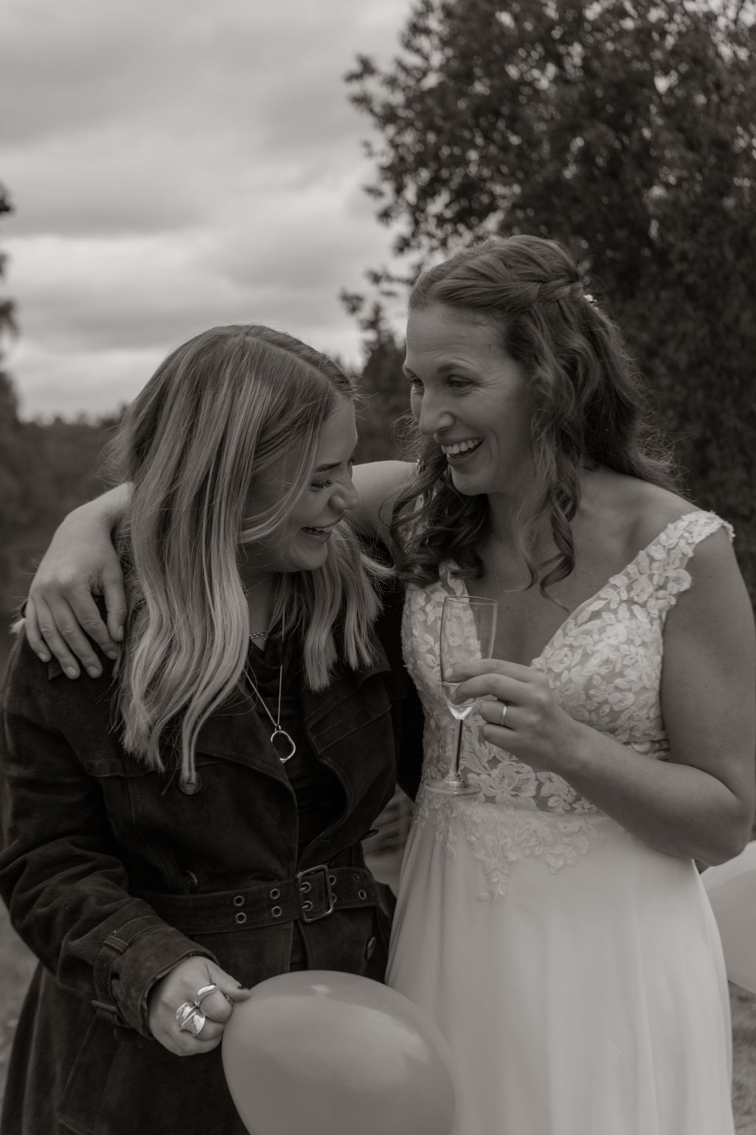 A couple shares intimate laughing moments together during an outdoor wedding photoshoot in black and white.