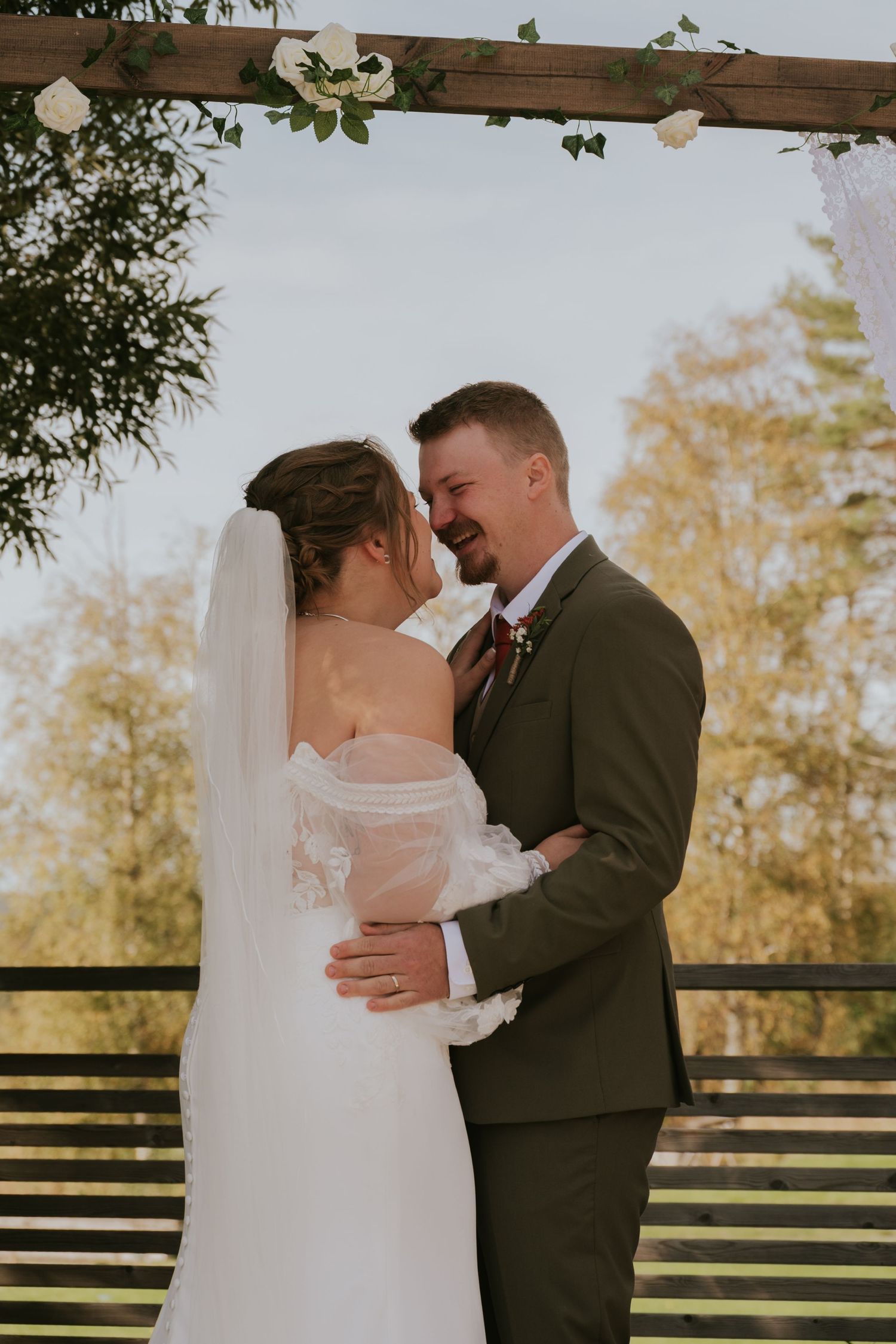 Newlyweds share a tender moment during their outdoor wedding ceremony.