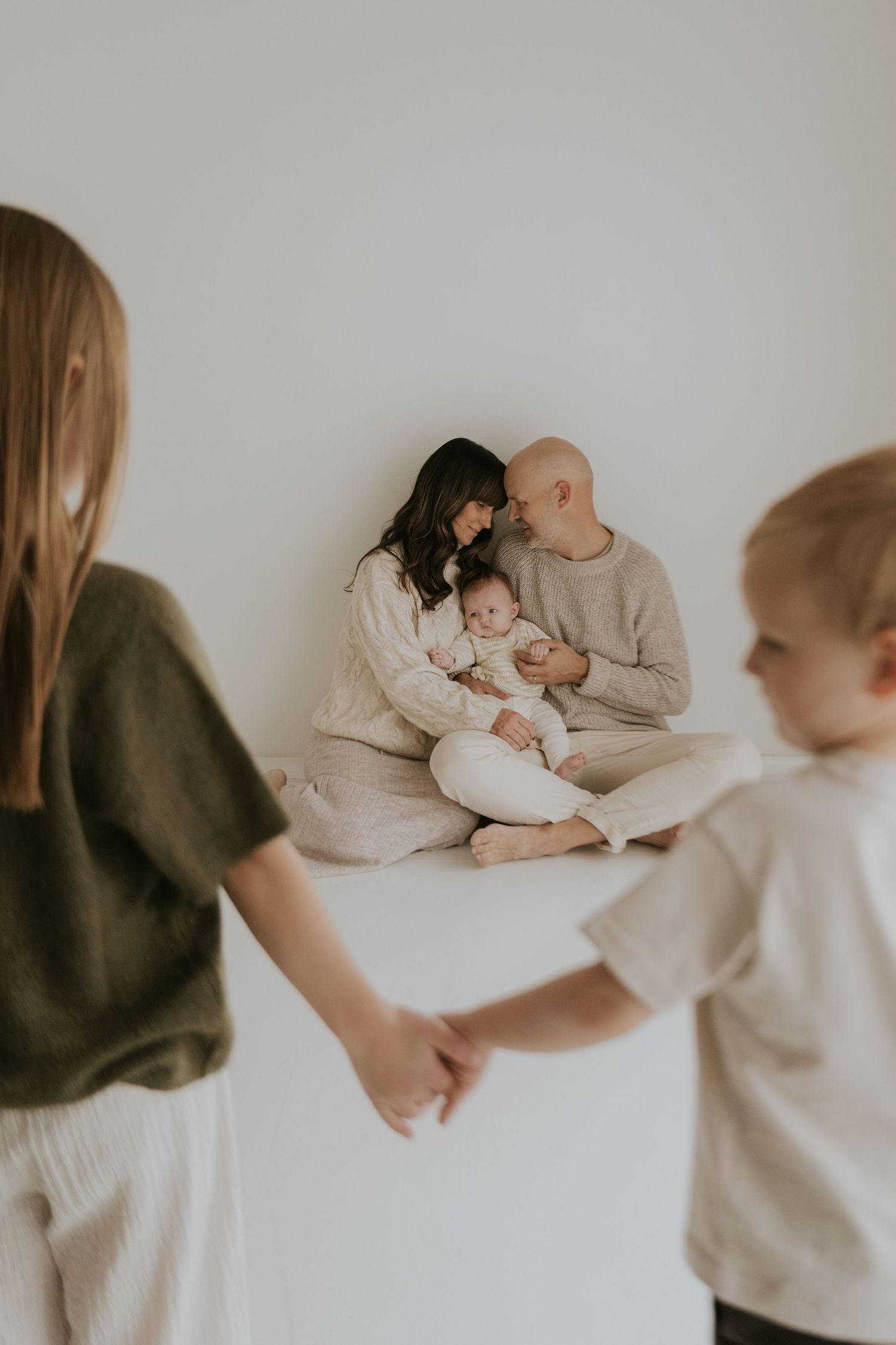 Lifestyle family photography session showing playful interactions in minimalist setting.