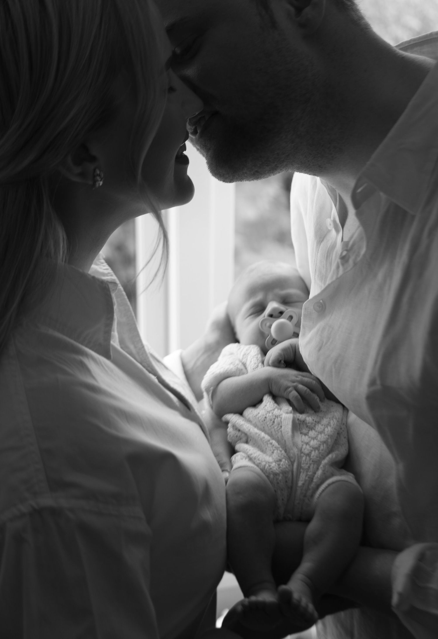 A tender black and white photo sequence showing a couple sharing intimate moments together in soft lighting.