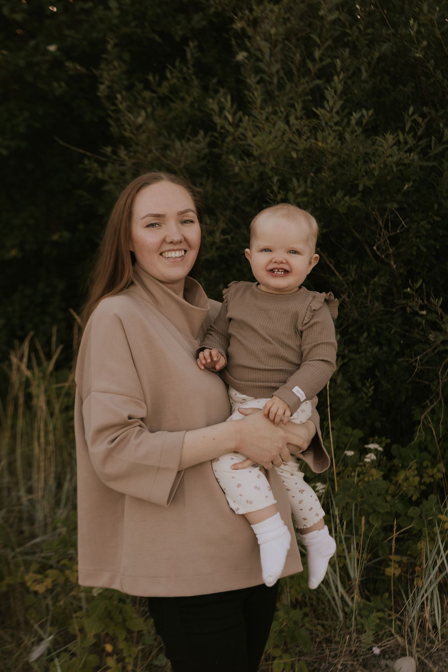 Candid outdoor portraits showing joyful moments between two people in neutral toned clothing.