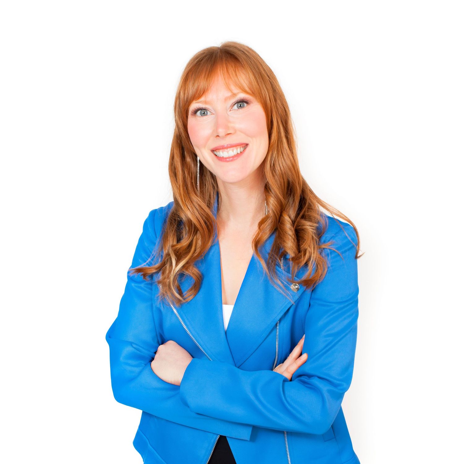 Confident redhead woman in blue blazer with arms crossed against white background.