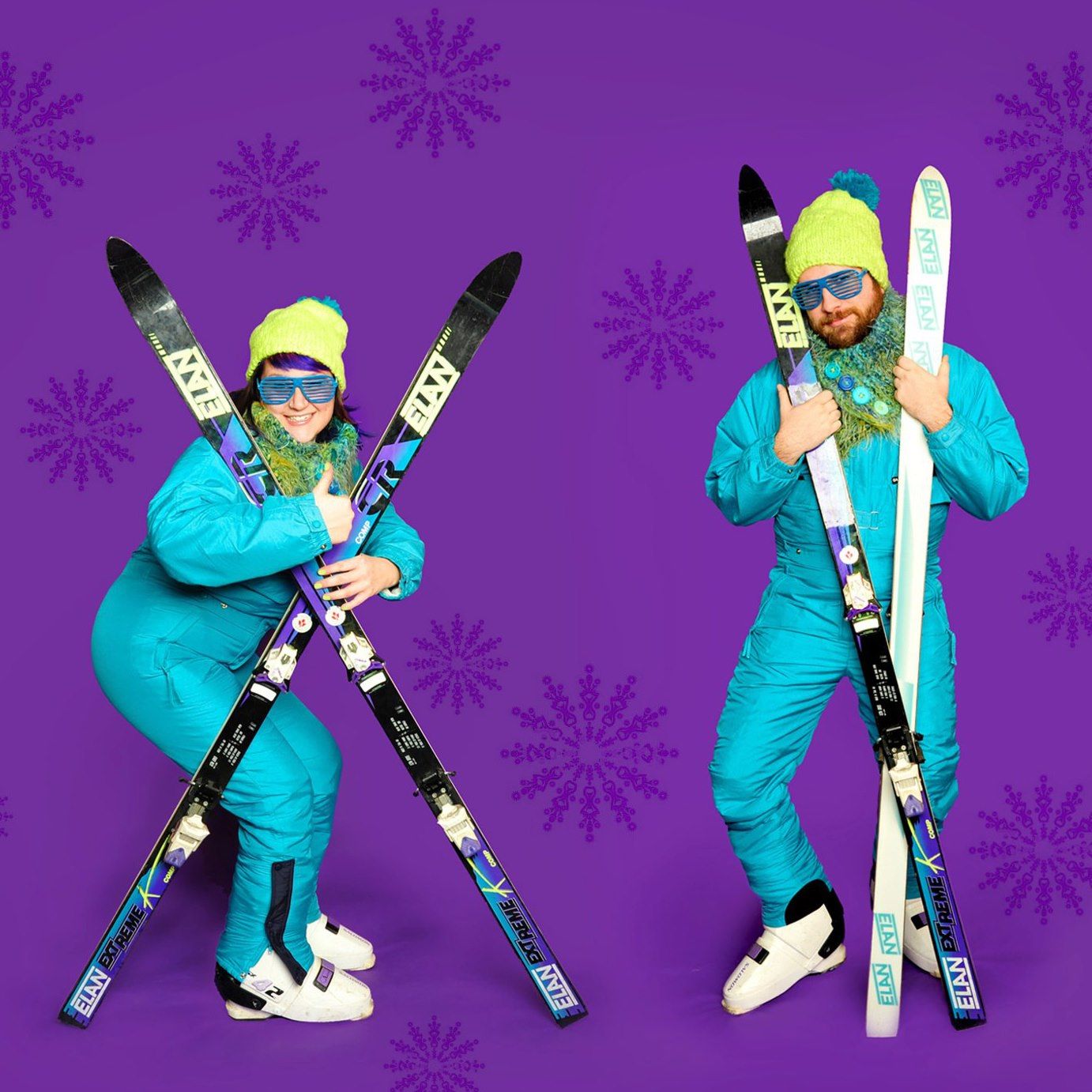 Two people in retro teal ski suits holding skis on purple snowflake background.