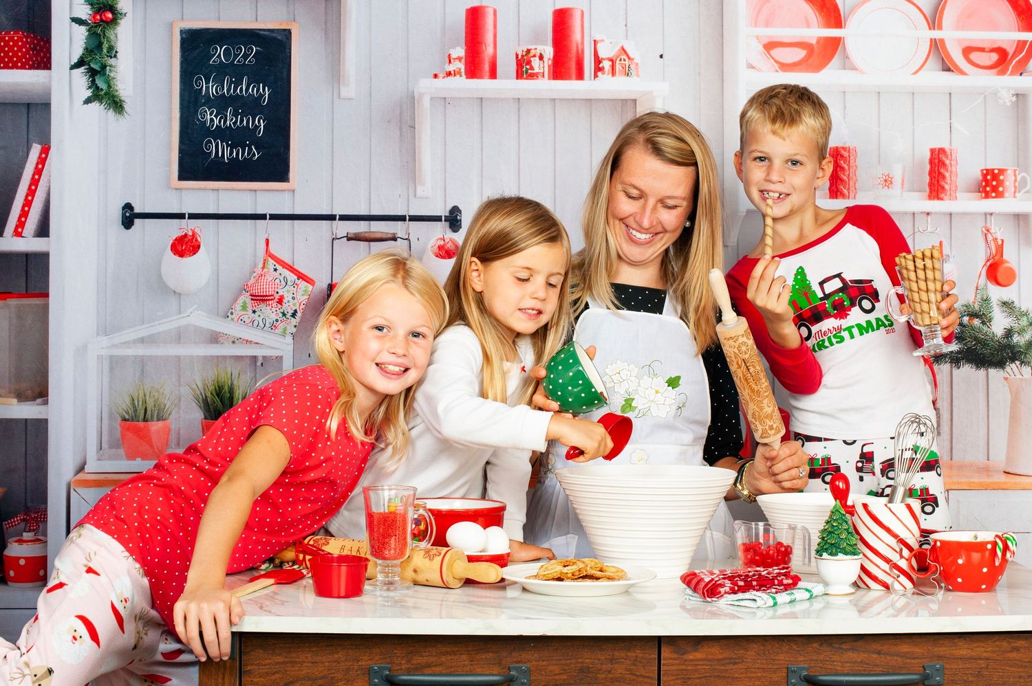 Happy family baking Christmas cookies together in a festive red and white holiday kitchen.