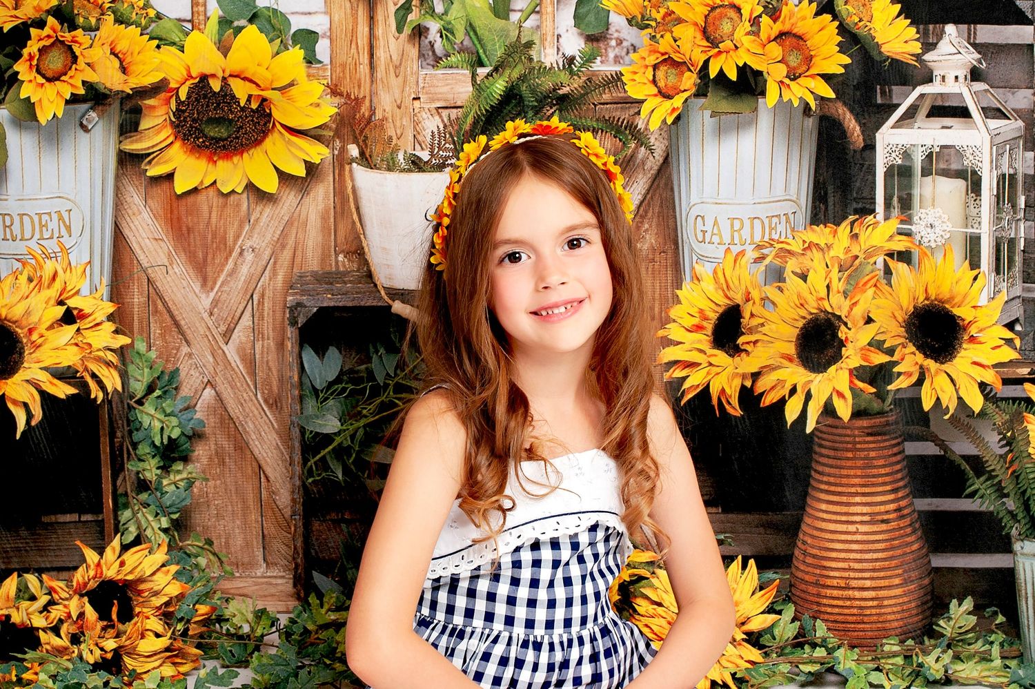 Smiling girl with floral crown posing among vibrant sunflowers and rustic garden decor backdrop.