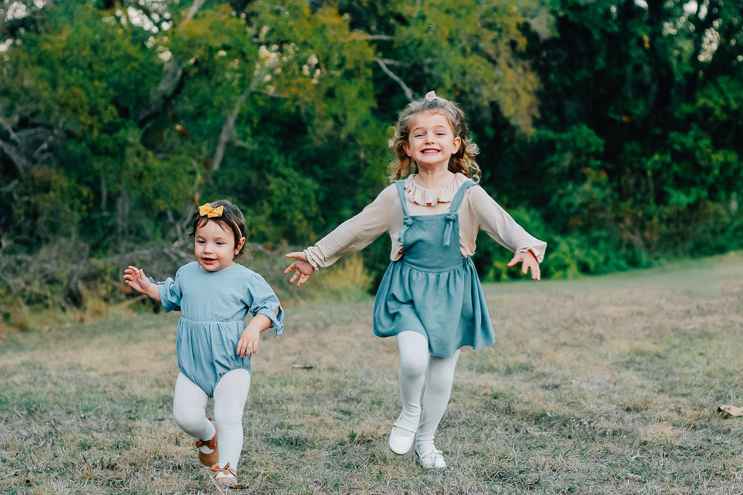 Sequence showing joyful movements of small child in blue dress against natural backdrop.