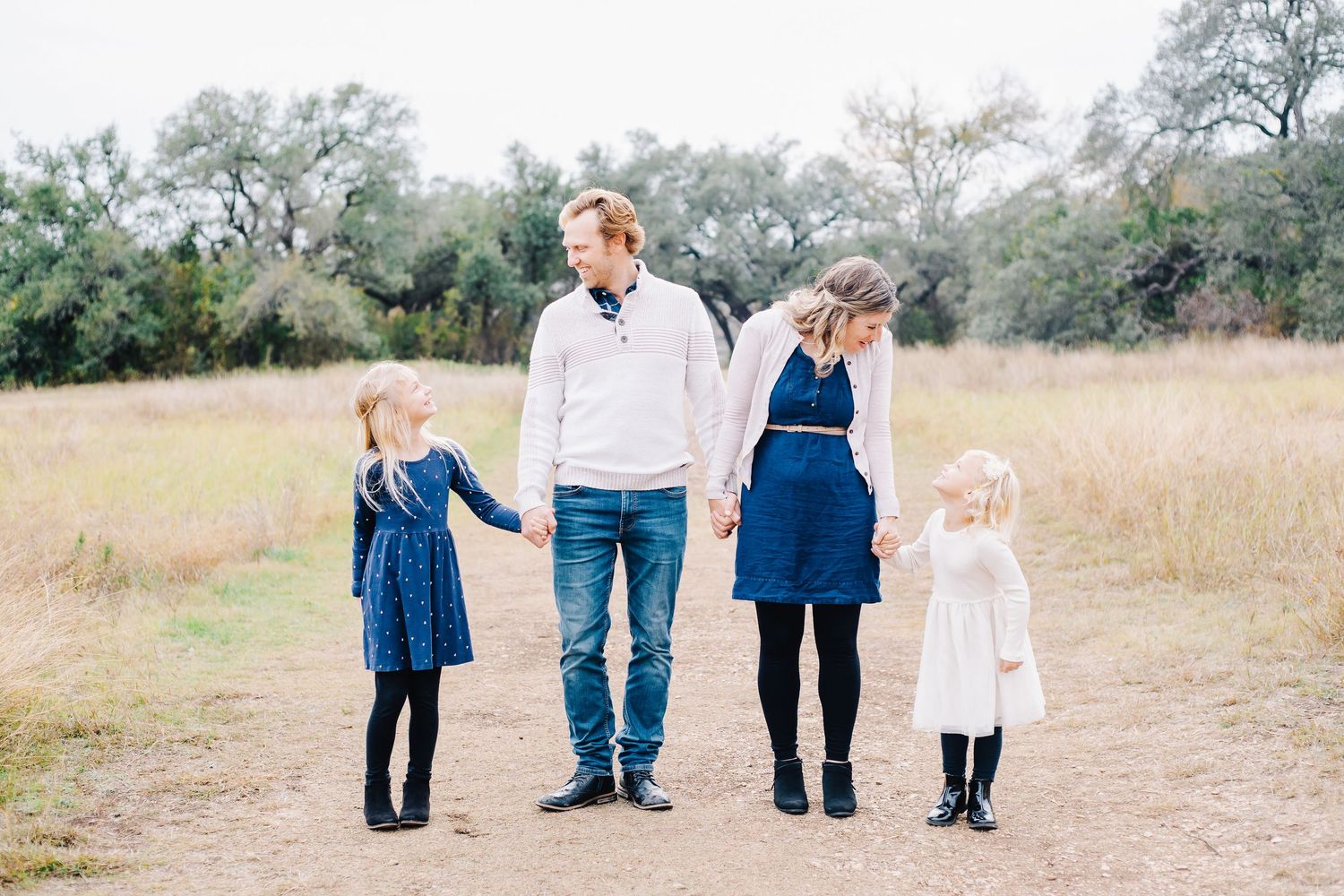 Family members walking together in casual clothing through a natural outdoor setting.