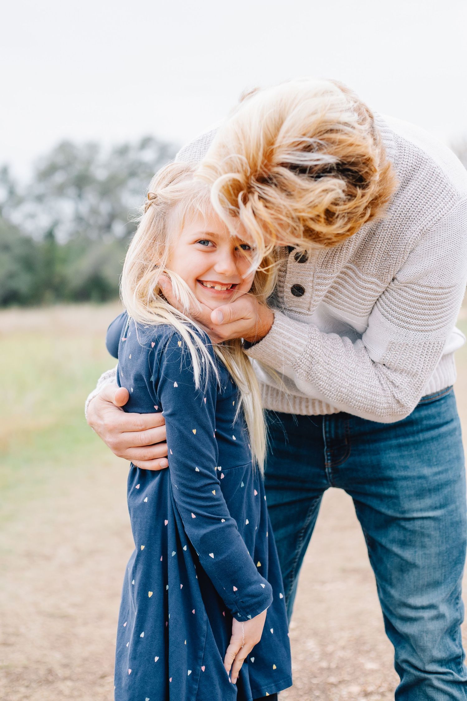 Candid family moment captured in a series of playful poses outdoors.