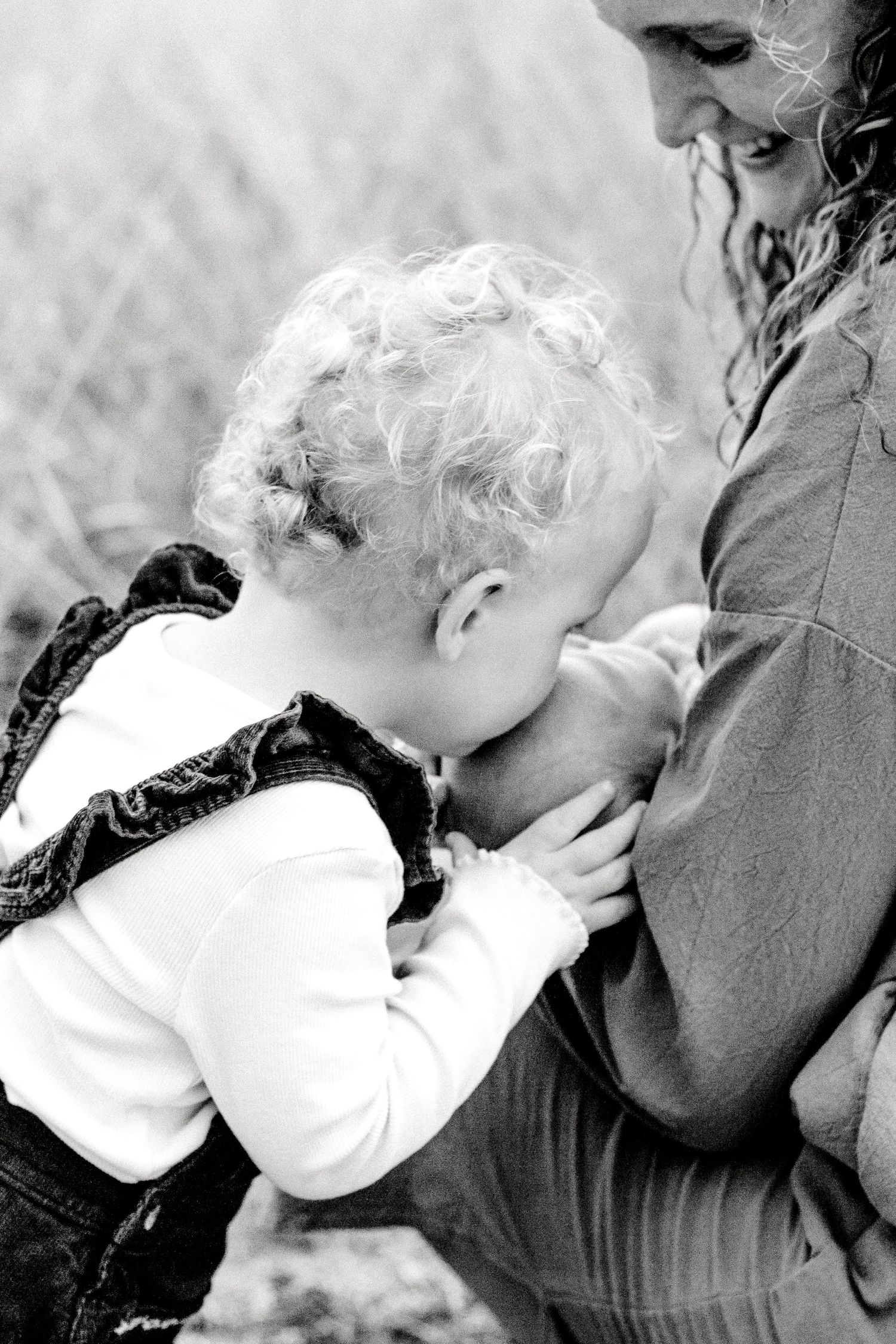 Black and white portrait series showing tender moments between parent and baby in close-up.
