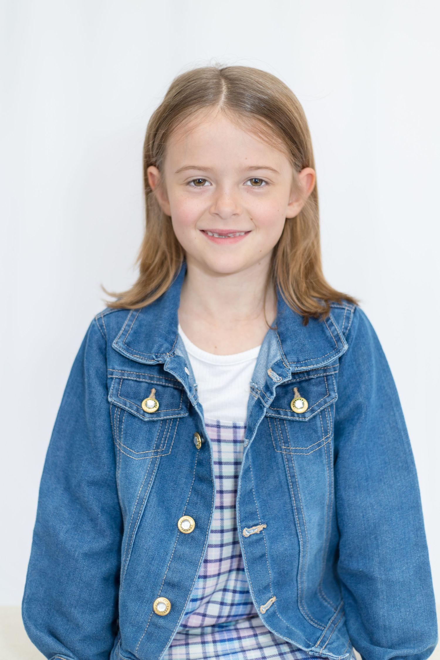 Portrait series in casual denim jacket and plaid outfit with natural lighting.