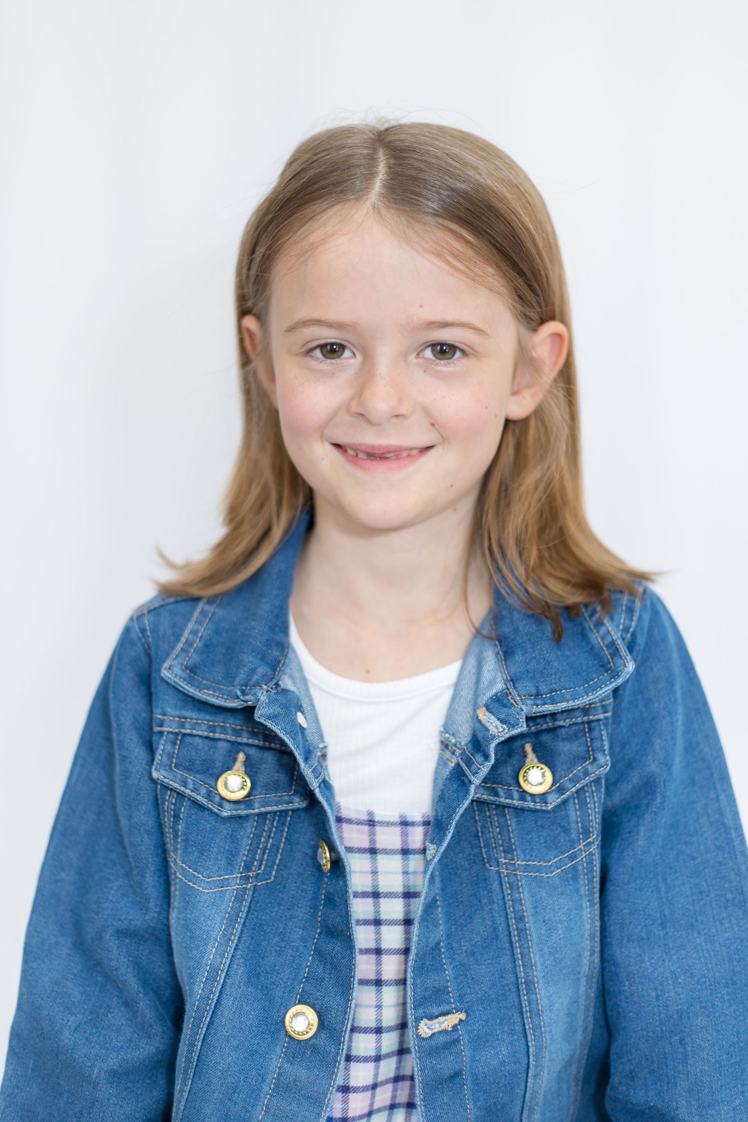 Professional headshots wearing denim jacket and plaid outfit against white backdrop.