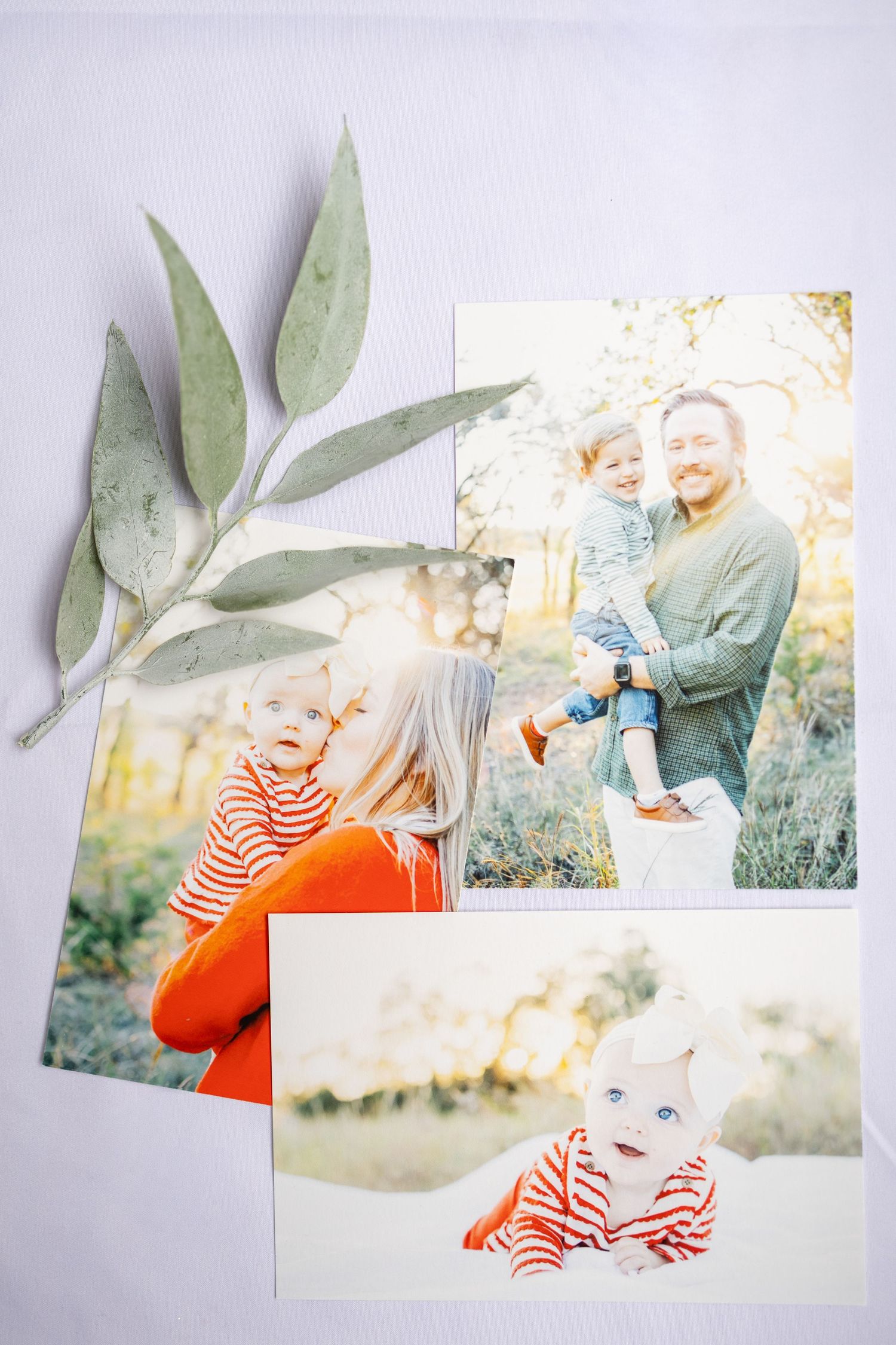 Collection of candid family photos displayed with eucalyptus leaves on white background.