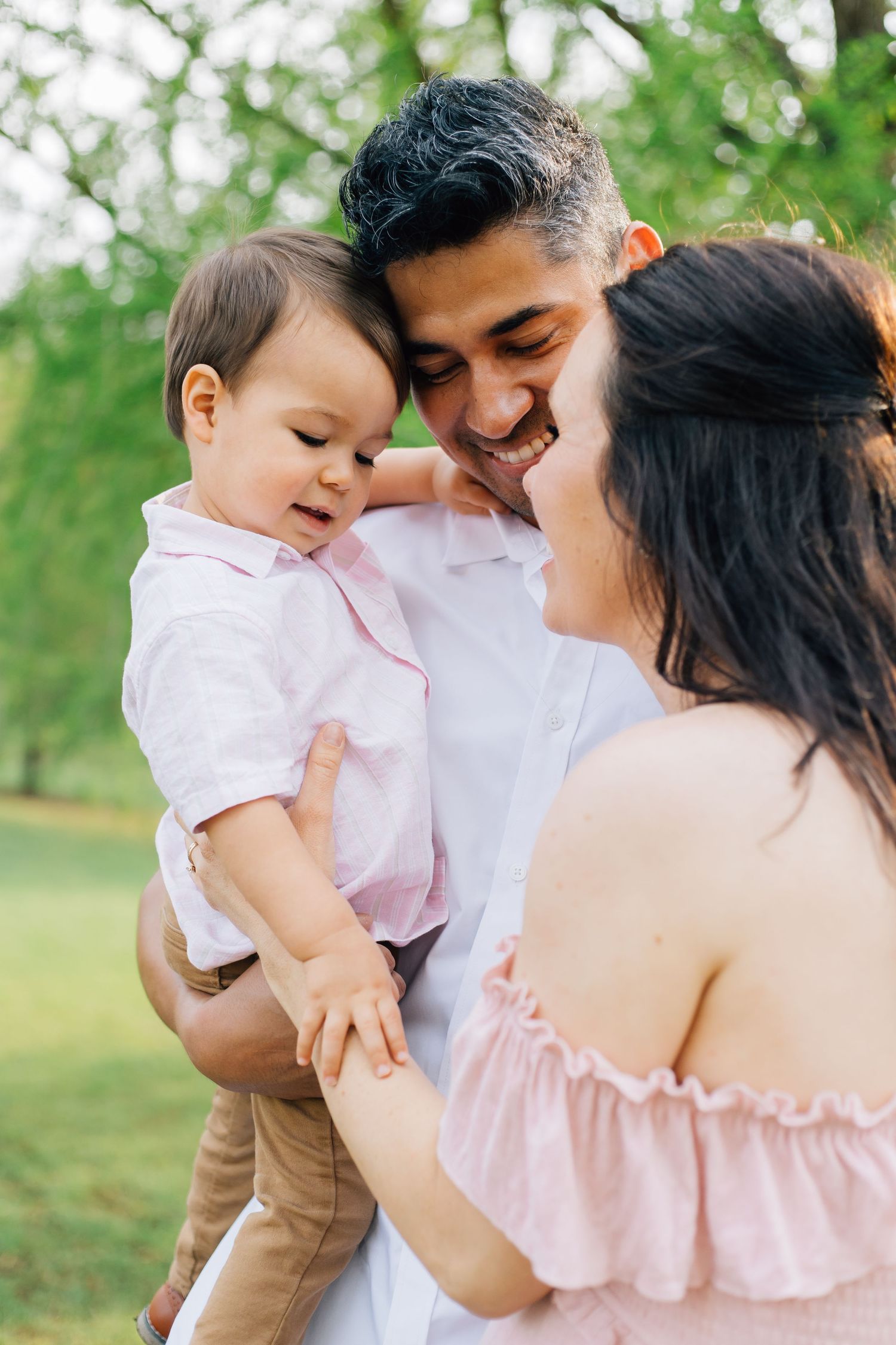 An intimate family moment captured during an outdoor photoshoot with soft natural lighting.