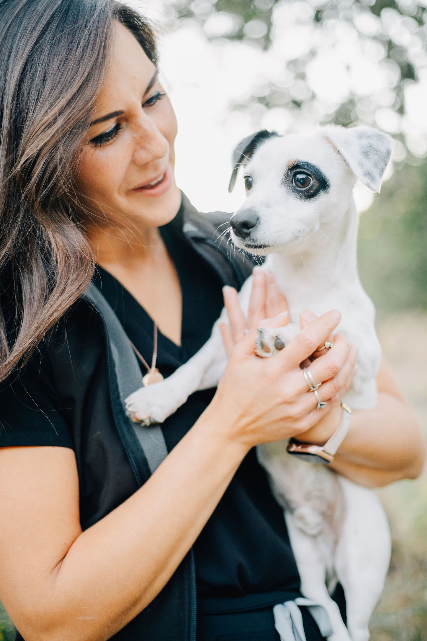 Close-up shots of a woman bonding with her small white dog in natural lighting.
