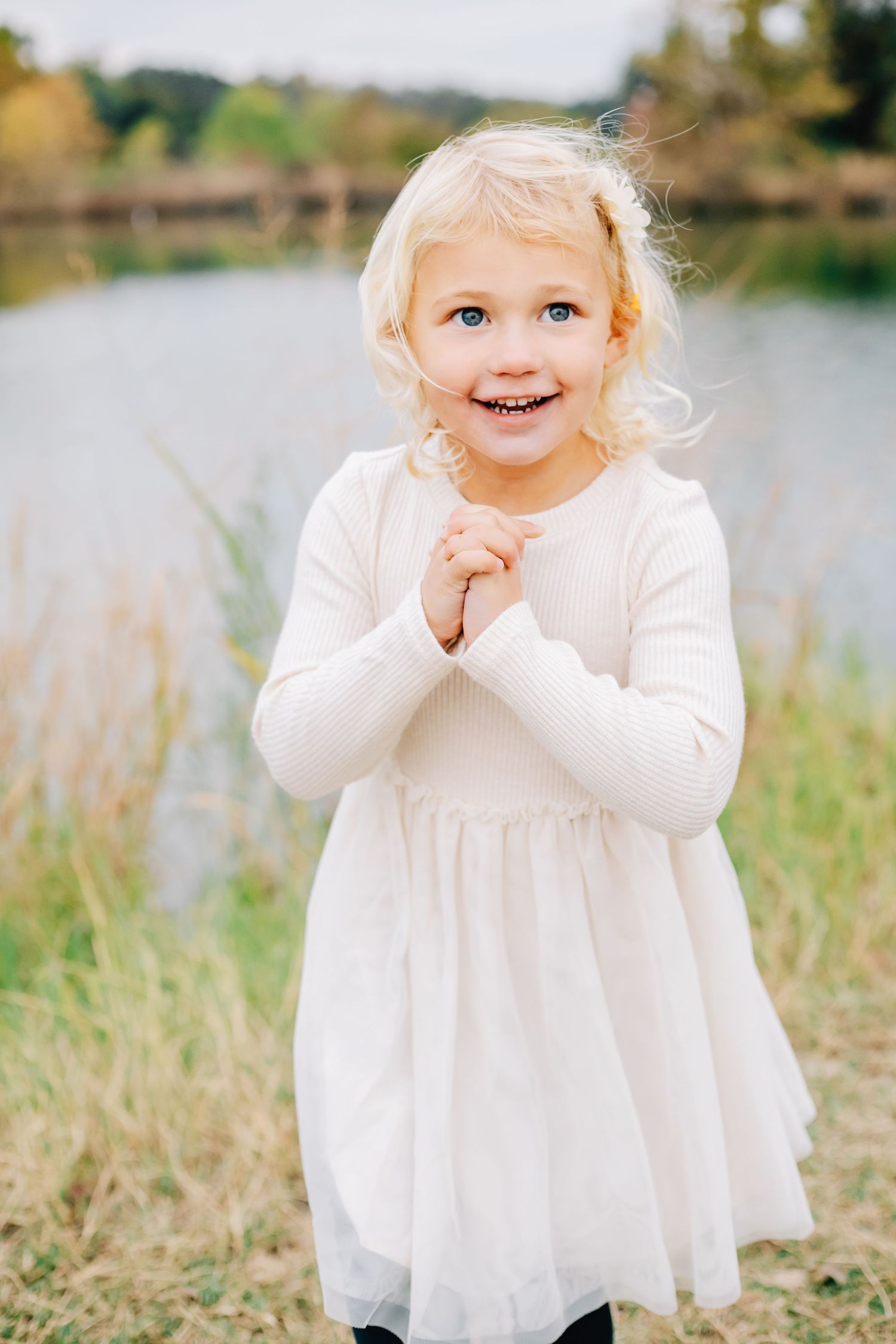 A series of outdoor portraits showing a small child in a white dress making playful expressions.