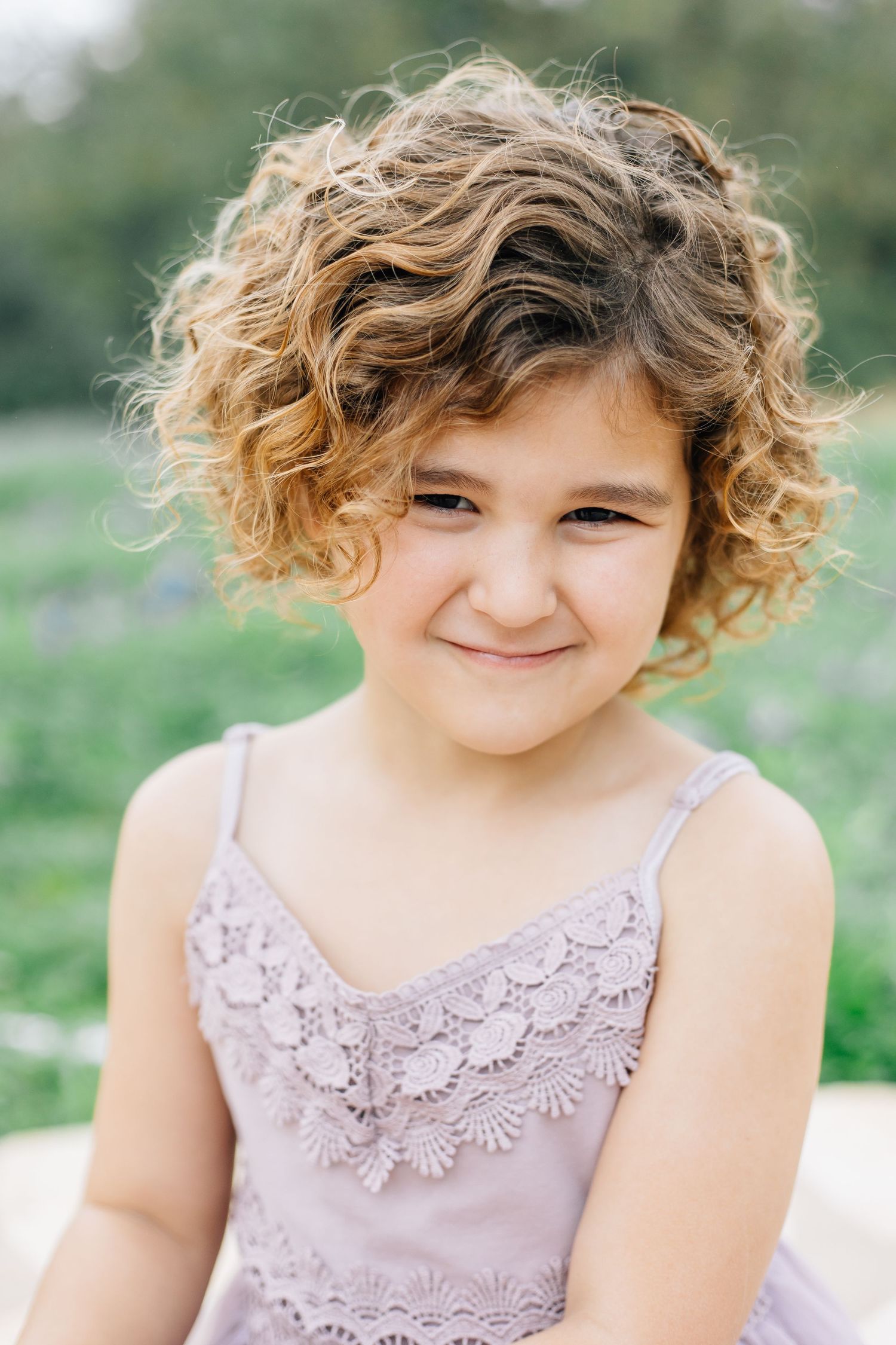 Close-up portraits showing curly hair and lilac dress details in natural lighting.