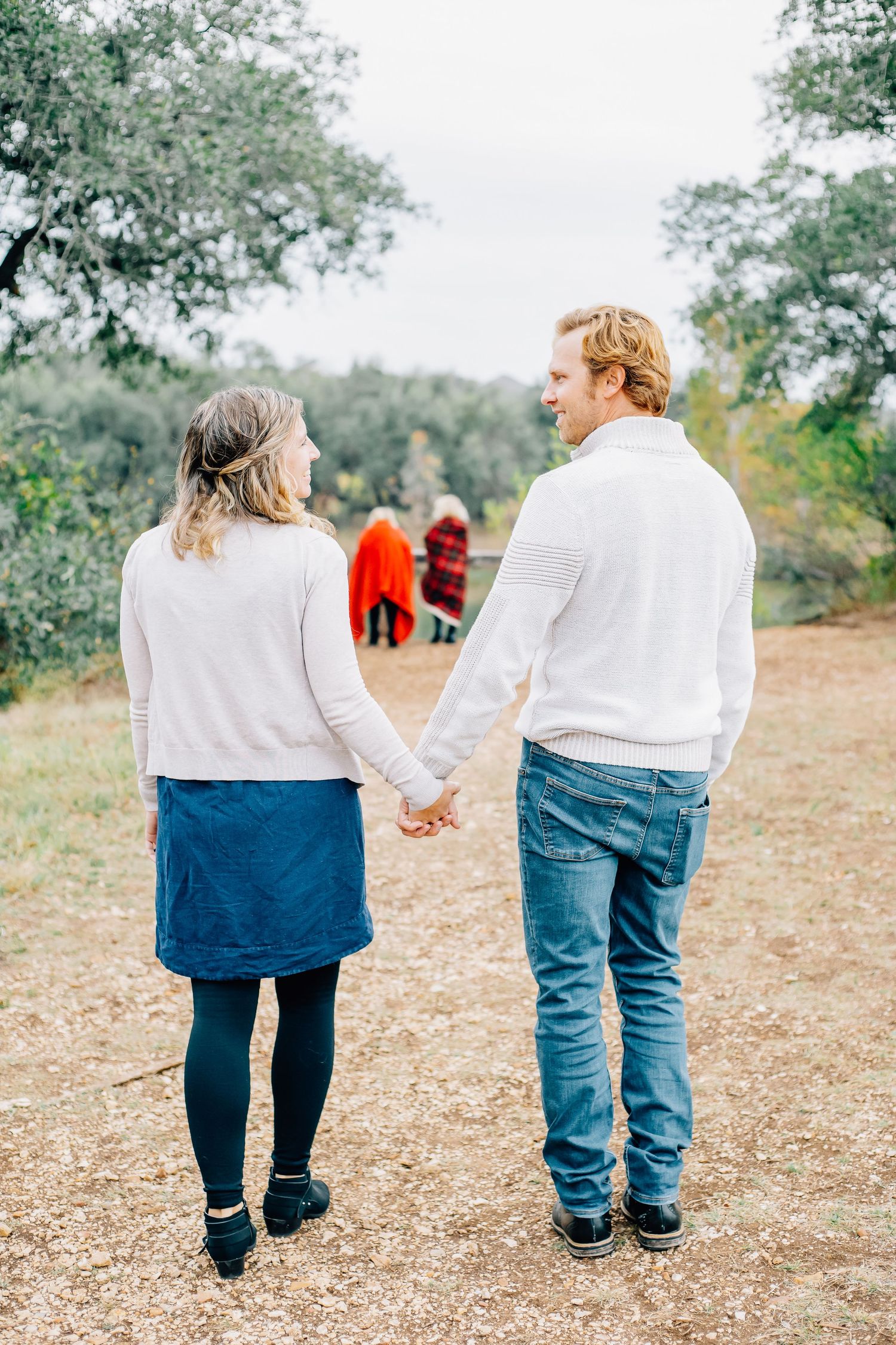Family walking together hand in hand through a scenic outdoor area.