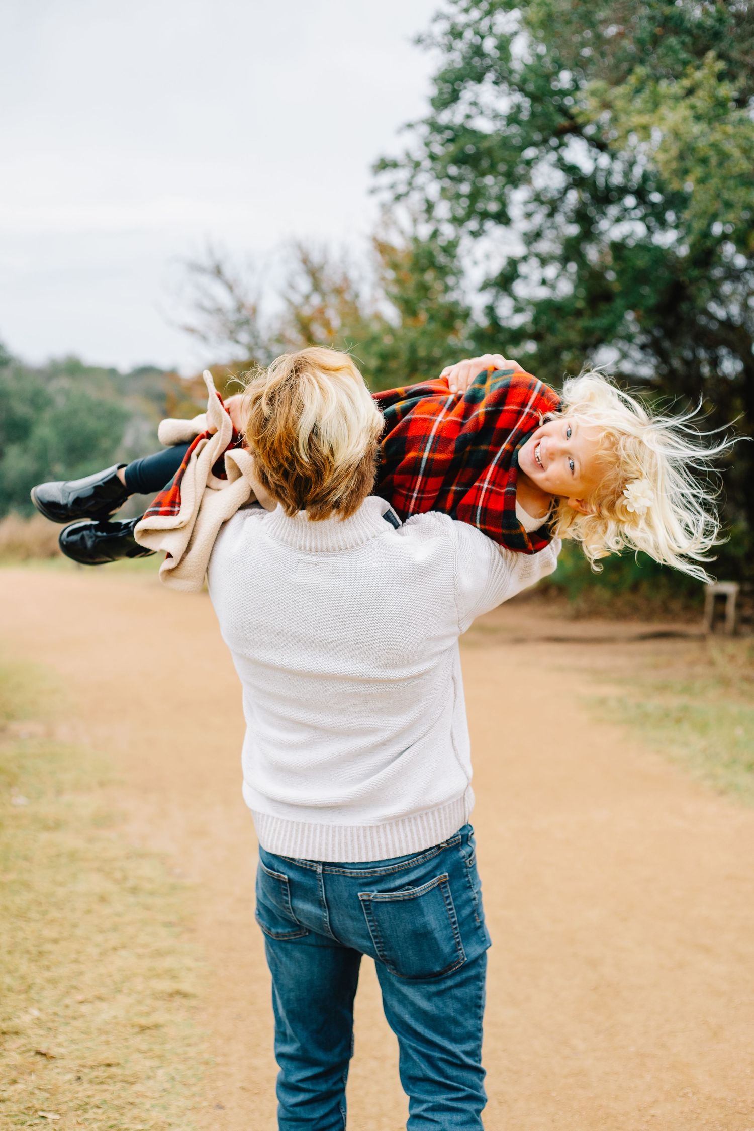 Person in white sweater and jeans playfully bending backwards in a series of outdoor photos.