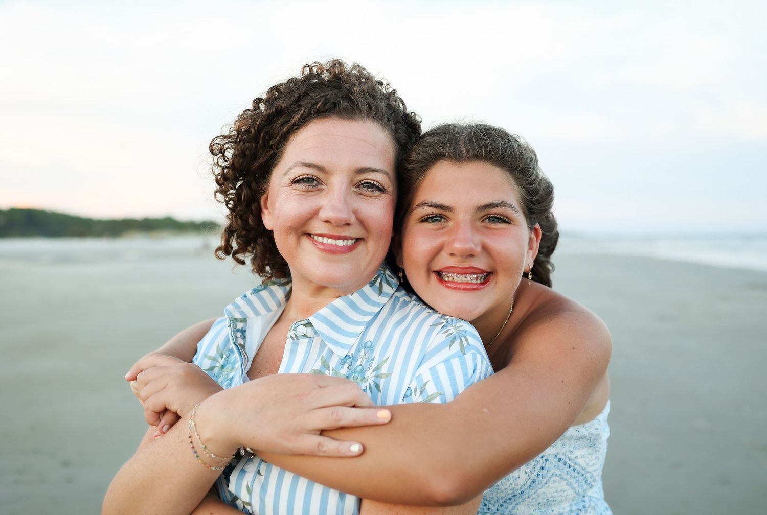 Hilton Head family photographer capturing a teen hugging her mom during beach photos at Singleton Beach