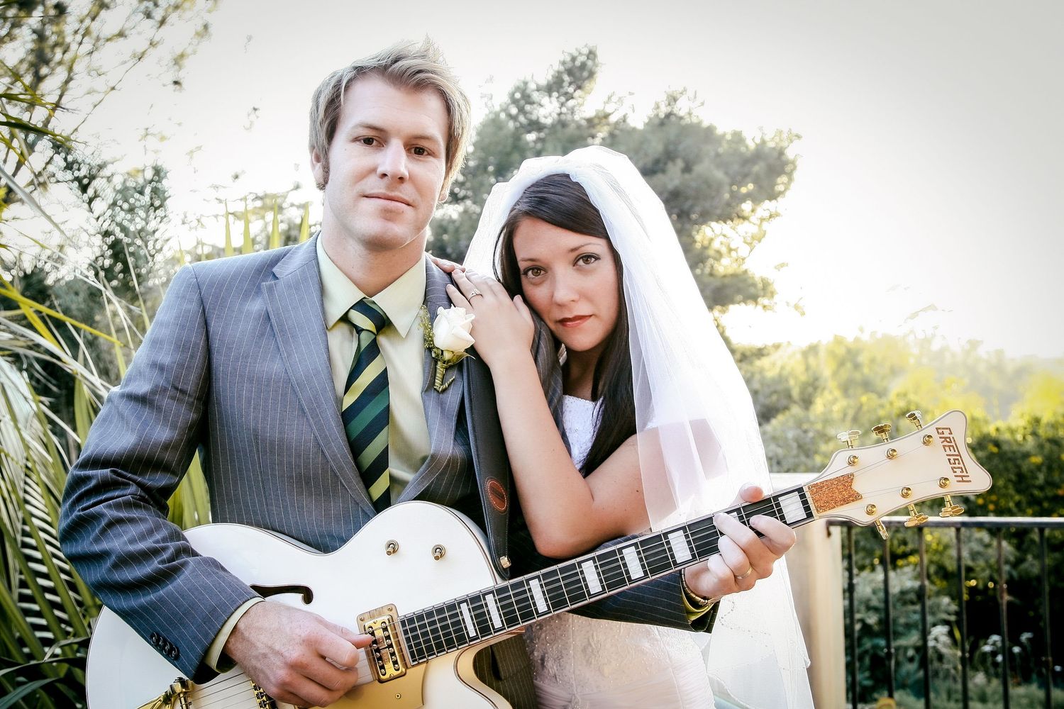 Bride and groom posing with white Gretsch guitar during Hilton Head wedding photography session