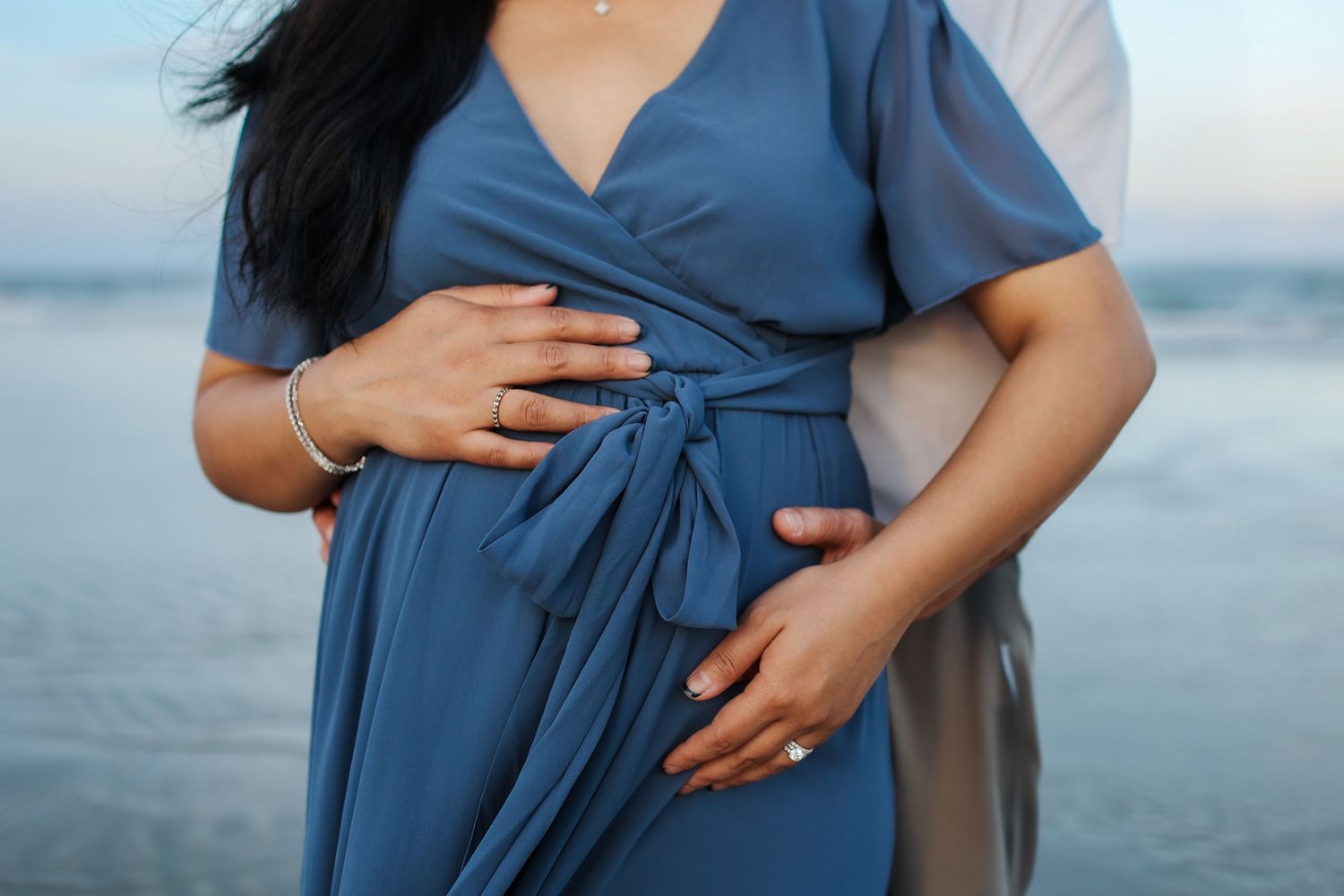 Hilton Head maternity photography session with couple holding baby bump at sunset on Burkes Beach