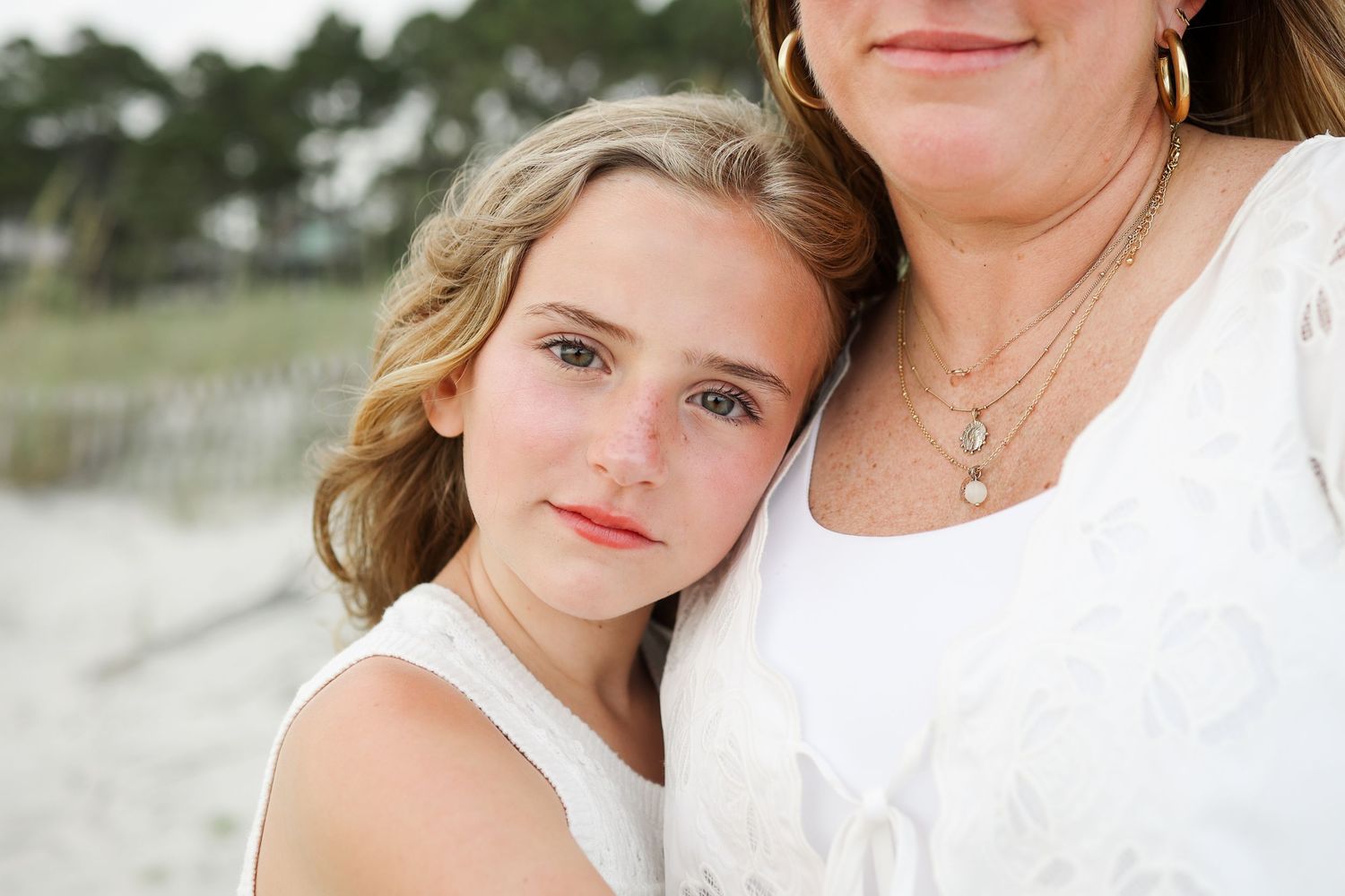 Hilton Head family photos showing a young girl hugging her mother during an intimate beach portrait