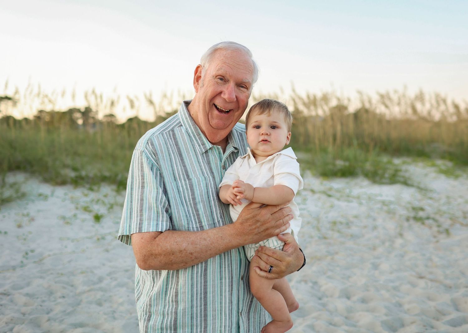 Grandfather holding grandson during extended family photos at Burkes Beach on Hilton Head Island