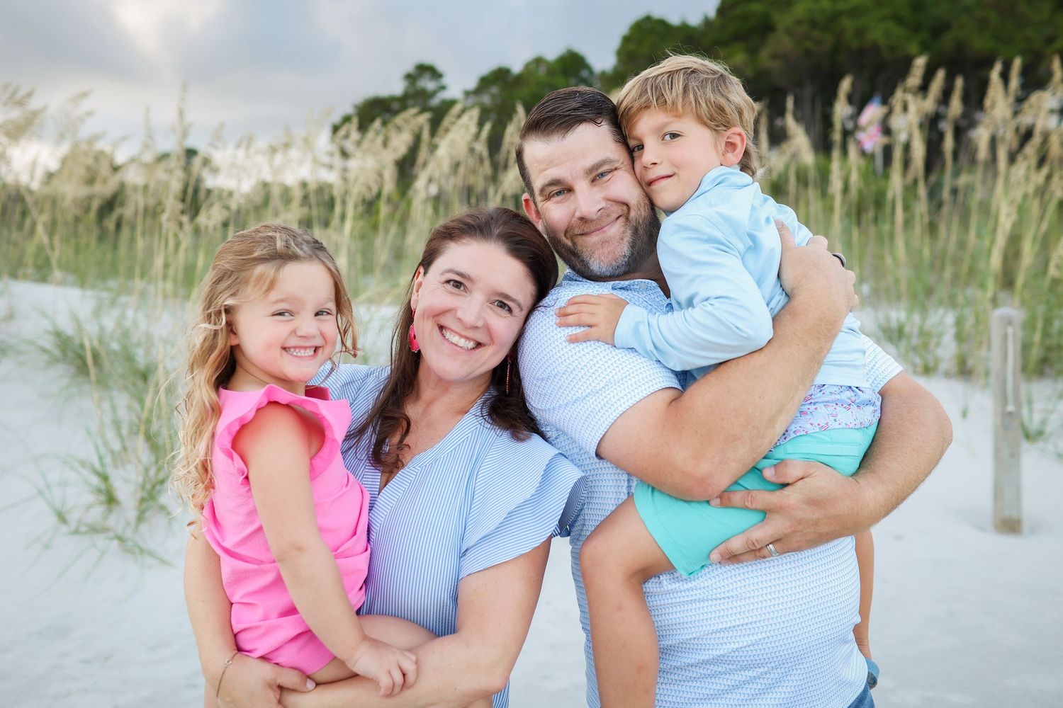 Hilton Head family photography with young family smiling together during beach portraits at South Forest Beach