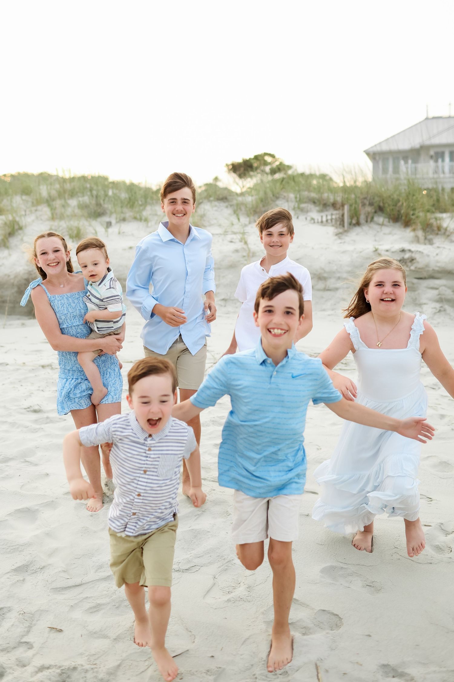 Extended family photography on Hilton Head Island with grandchildren running through sand dunes during a joyful family session