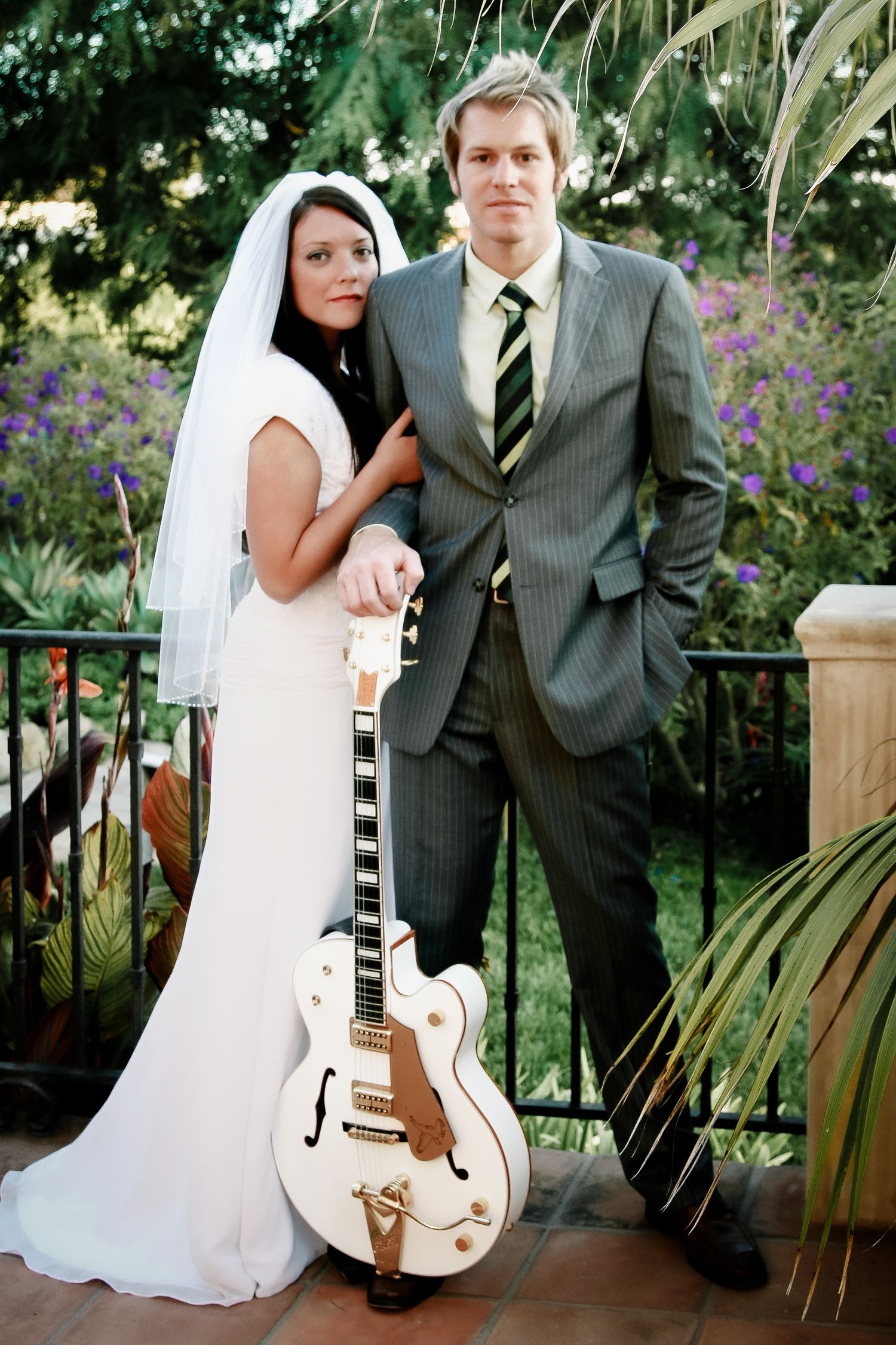 Bride and groom posing with white Gretsch guitar during Hilton Head wedding photography session