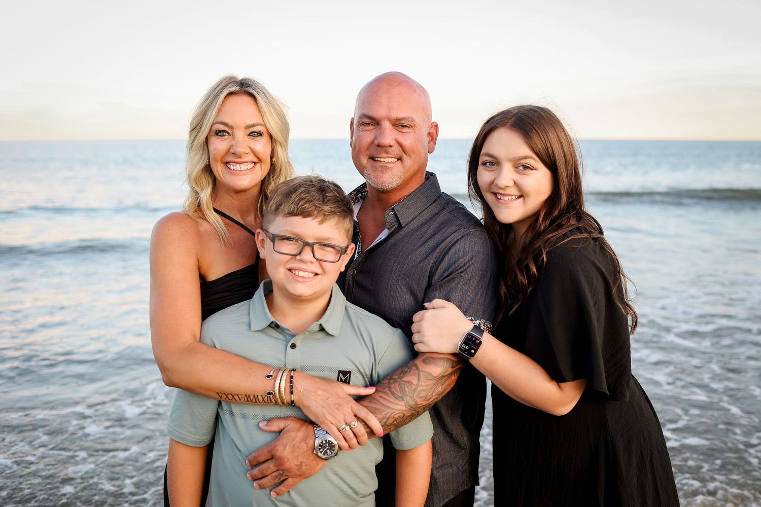 Hilton Head Island family photography with parents and children smiling at sunset at Sea Pines Beach Club by the ocean