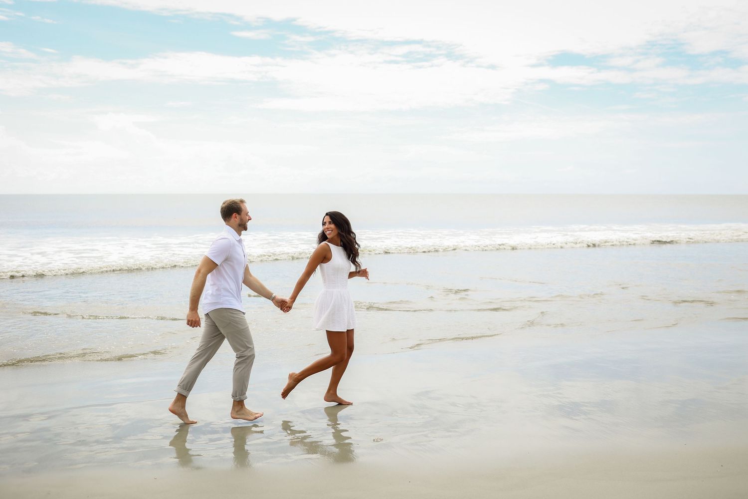 Engagement photos on Hilton Head Island, couple running along shoreline at Folly Field Beach