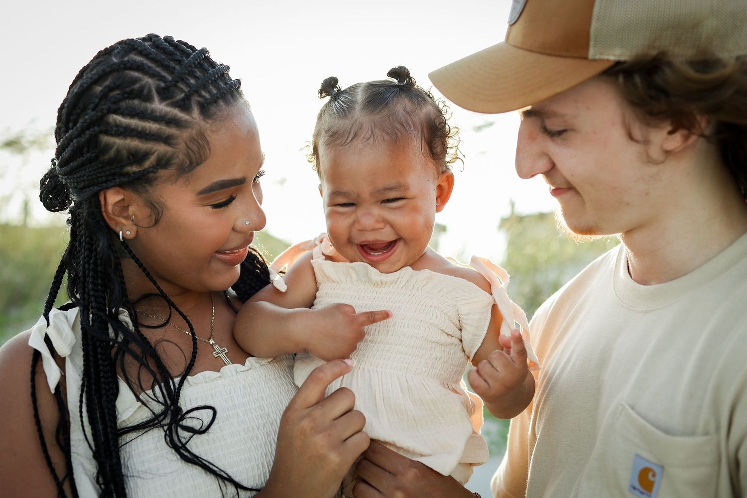 Hilton Head Island family photography with parents holding a laughing baby during beach photos at Driessen Beach