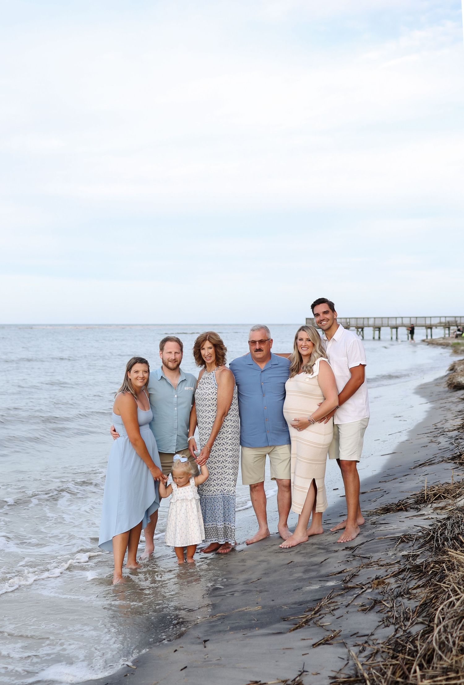Extended family photography session at Fish Haul Beach on Hilton Head Island, family posing together in shallow water