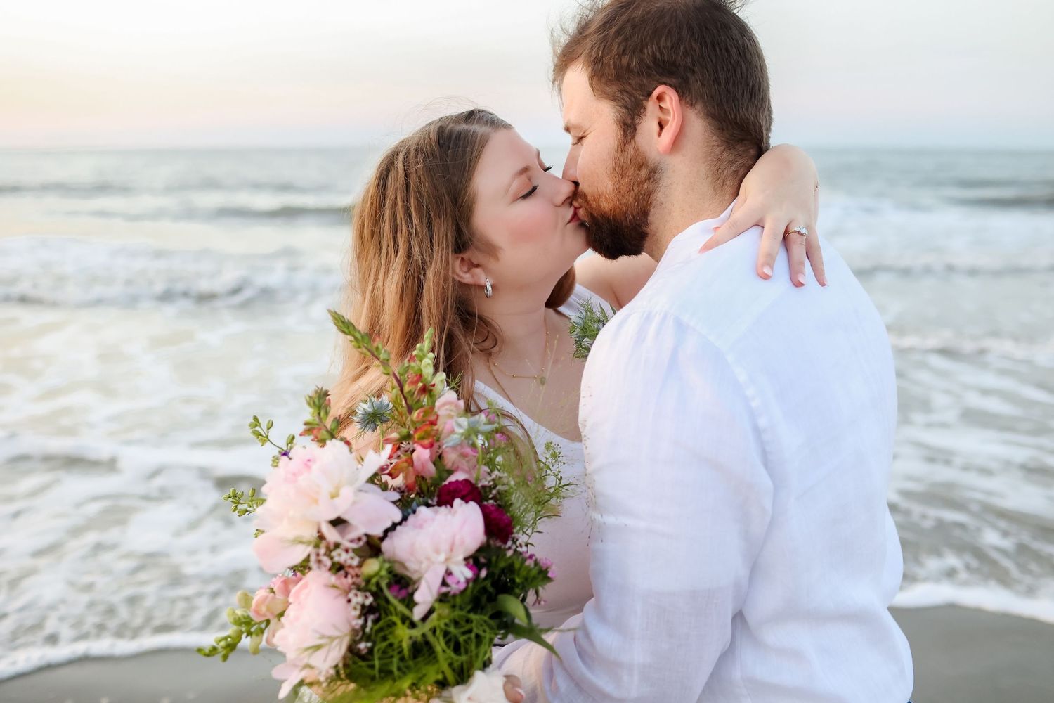 Newly married couple kissing on Folly Field Beach after sunrise elopement on Hilton Head Island