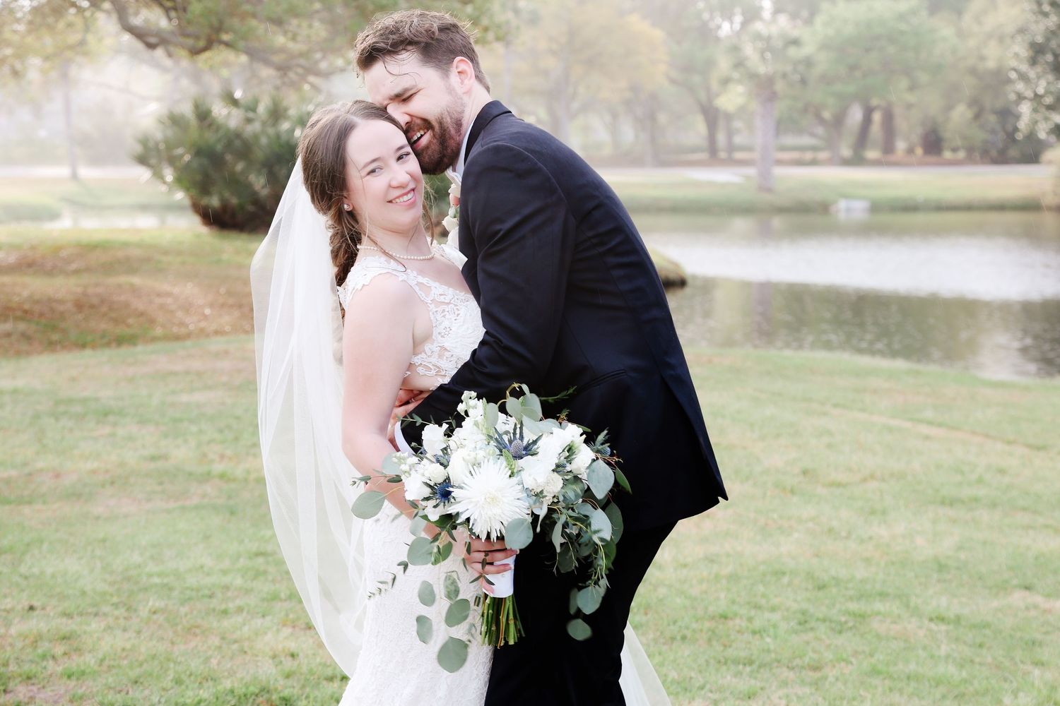 Groom hugging his bride beside a lagoon during Hilton Head wedding photography portraits
