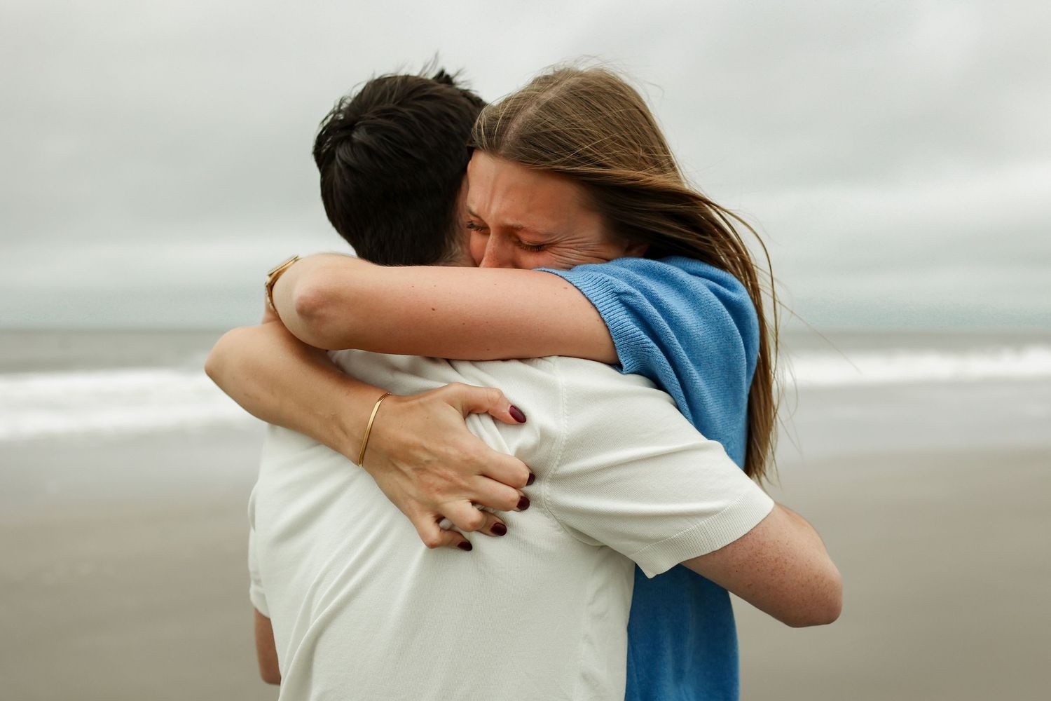Surprise proposal photography on Hilton Head Island, woman hugging fiancé after proposal at Burkes Beach